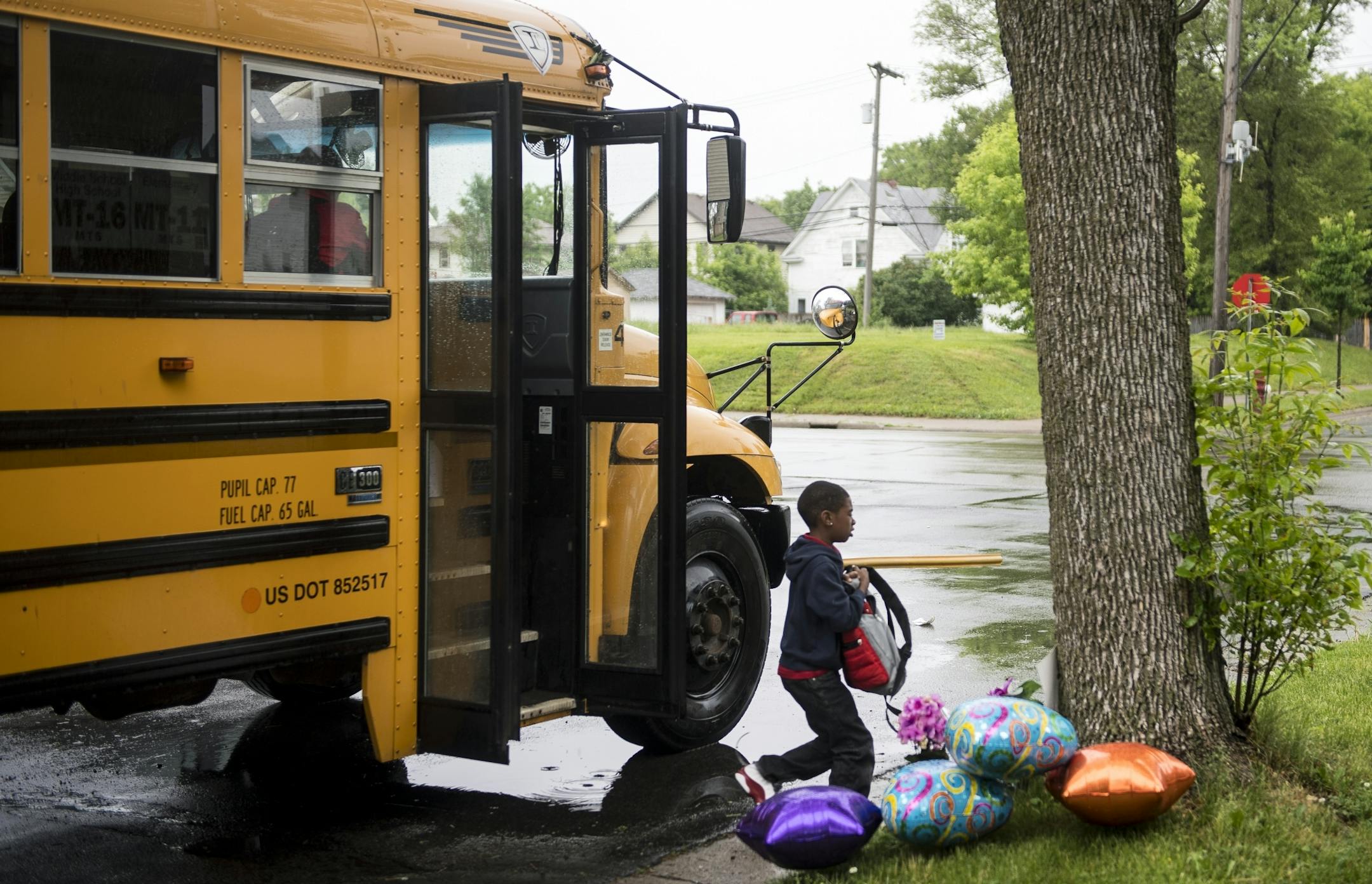 A young boy walked off the bus next to a memorial for Birdell Beatrice Beeks, a 59-year-old woman who was shot and killed Thursday night at Penn Avenue North and North 21st Avenue.