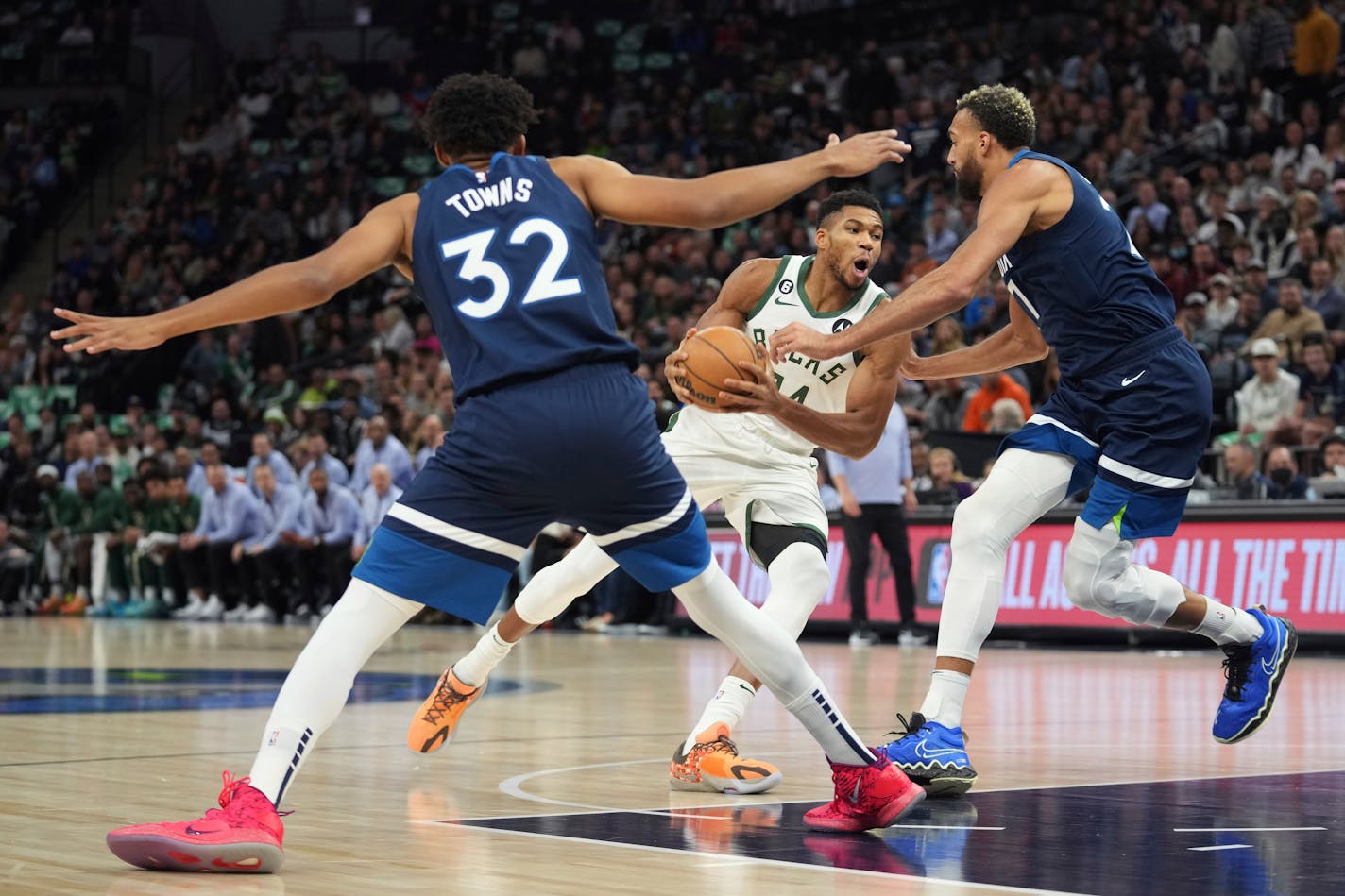 Bucks forward Giannis Antetokounmpo works toward the basket against Timberwolves center Karl-Anthony Towns and Rudy Gobert