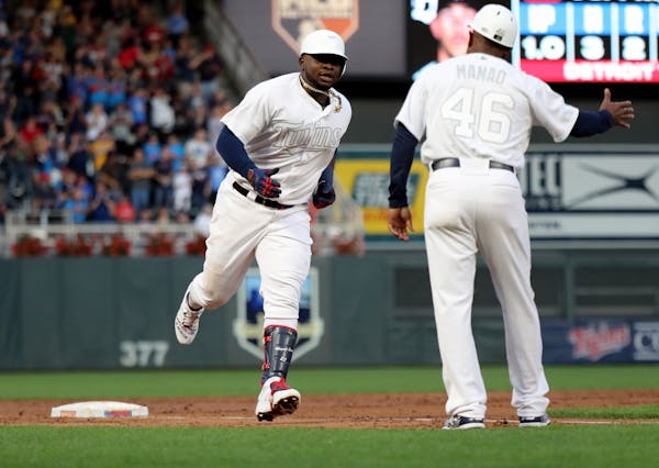 Minnesota Twins third baseman Miguel Sano was greeted by third base coach Tony Diaz after hitting a solo homer against the Detroit Tigers in the first