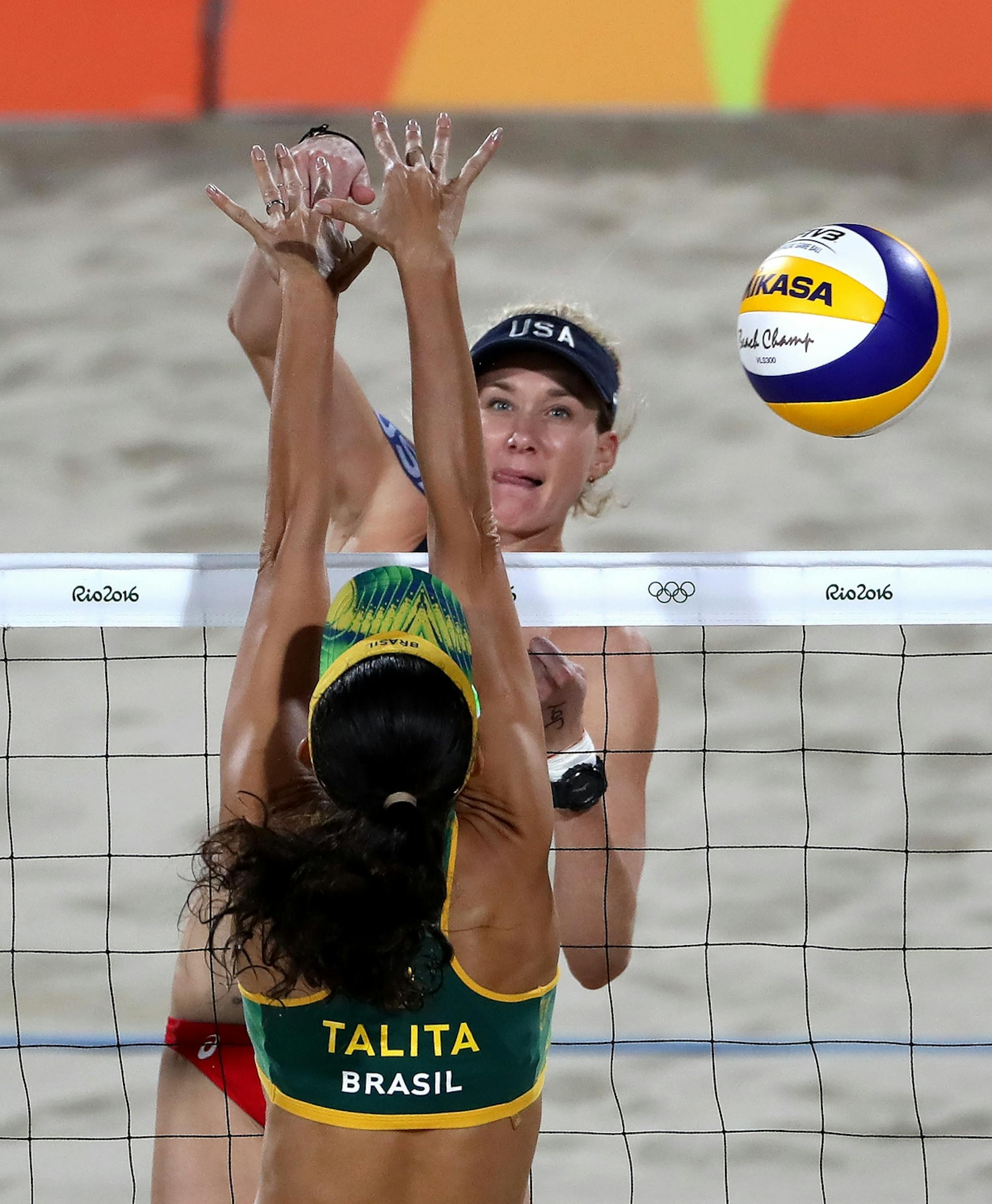 USA's Kerri Walsh Jennings spikes the ball over the blocking arms of Brazil�s Talita Rocha during the bronze medal game that she and April Ross won Wednesday night.