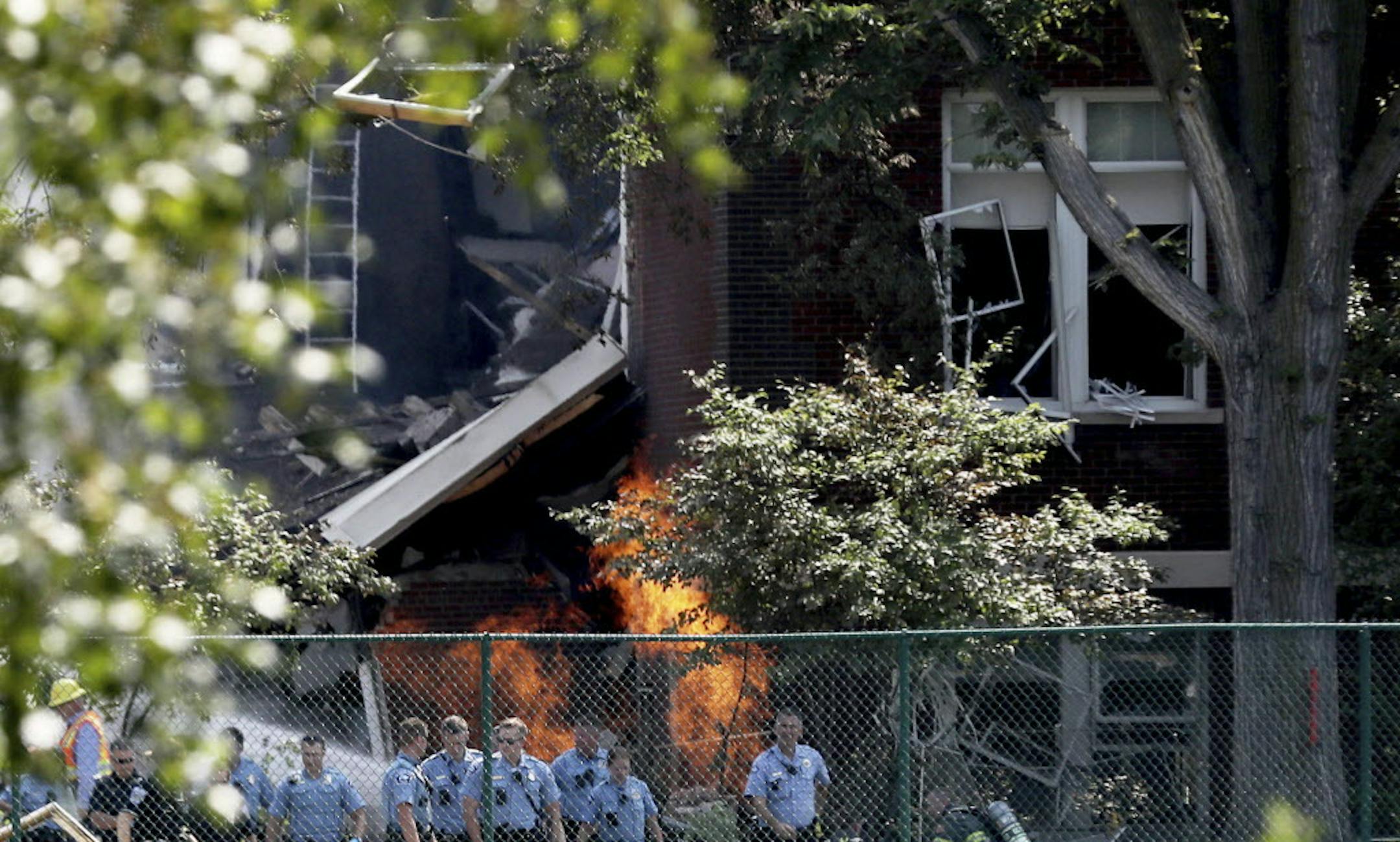 FILE - In this Aug. 2, 2017 file photo, emergency personnel move away as a gas fire continues to burn following an explosion at Minnehaha Academy in Minneapolis. A preliminary report released Monday, Aug. 21, 2017, by the National Transportation Safety Board about the school explosion, says a maintenance worker smelled natural gas and used a radio to tell others to evacuate just a minute before the blast. Two people died when part of a building collapsed. (David Joles/Star Tribune via AP File)/S