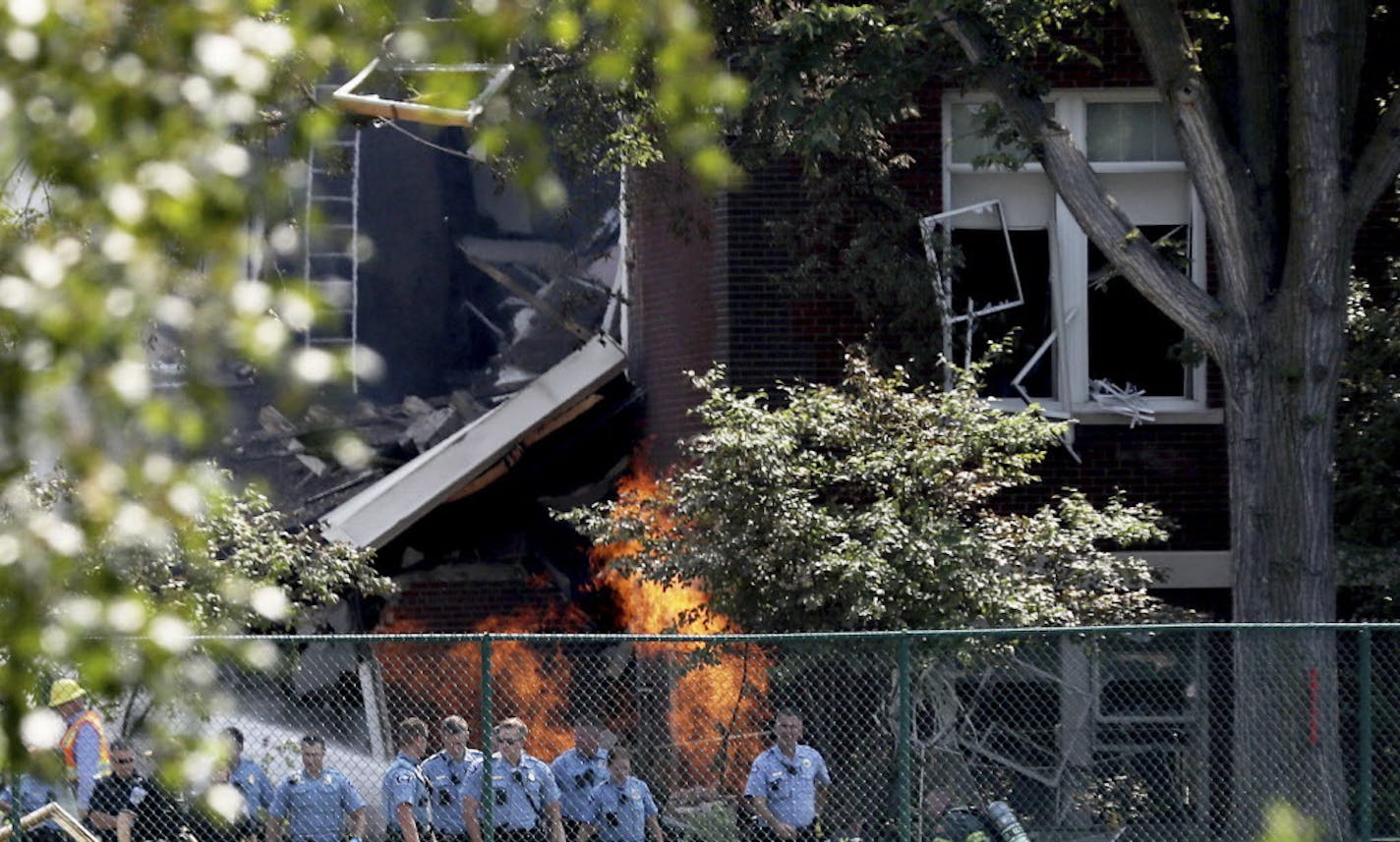 FILE - In this Aug. 2, 2017 file photo, emergency personnel move away as a gas fire continues to burn following an explosion at Minnehaha Academy in Minneapolis. A preliminary report released Monday, Aug. 21, 2017, by the National Transportation Safety Board about the school explosion, says a maintenance worker smelled natural gas and used a radio to tell others to evacuate just a minute before the blast. Two people died when part of a building collapsed. (David Joles/Star Tribune via AP File)/S