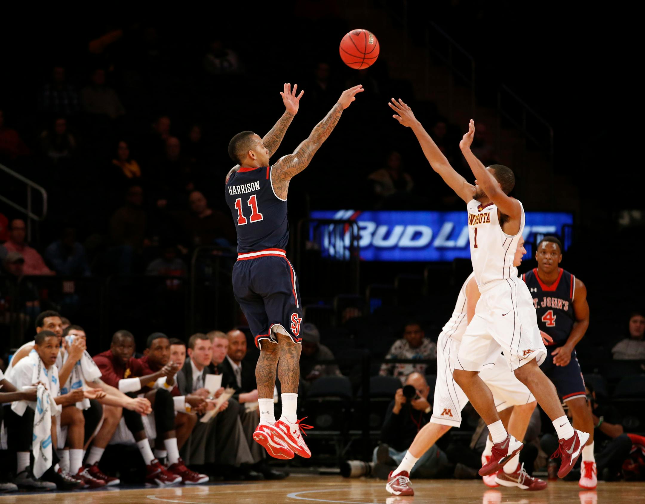 St. John's guard D'Angelo Harrison (11) shoots over Minnesota guard Andre Hollins (1) in the first half of an NCAA college basketball game in New York, Wednesday, Nov. 26, 2014. (AP Photo/Kathy Willens)