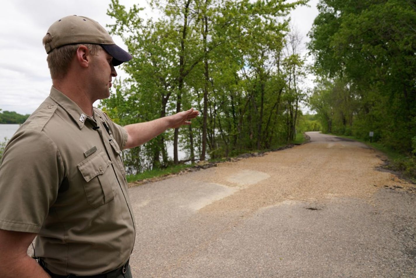 Assistant park manager Nick Bartels pointed to an area of the main road leading into Fort Snelling State Park that had been temporarily repaired in May after it was damaged by flooding. Six months after the flooding, the park is set to reopen.