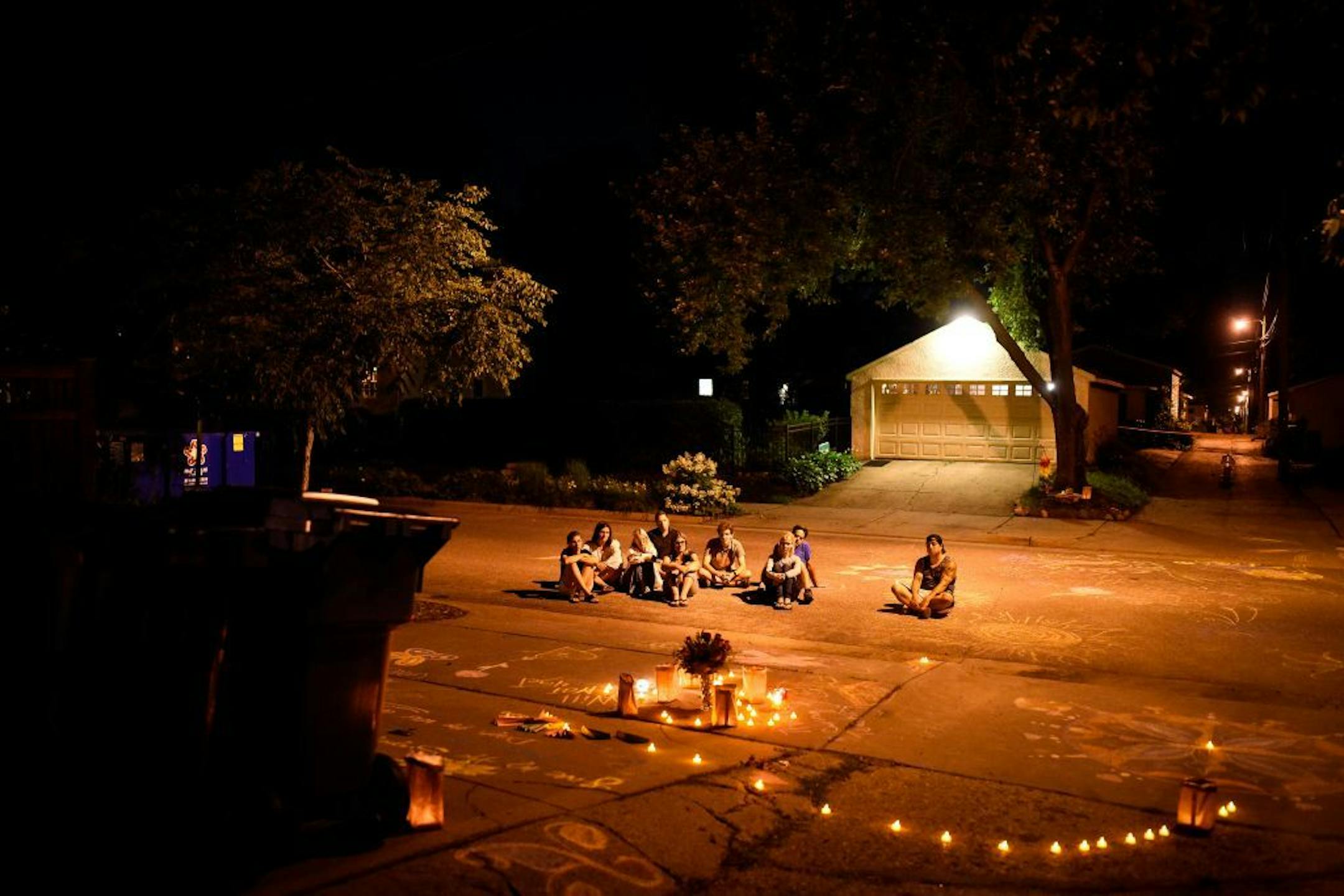 Friends and neighbors of Justine Damond Ruszczyk sat in silence near the spot where she was killed one year ago by Minneapolis Police officer Mohamed Noor .