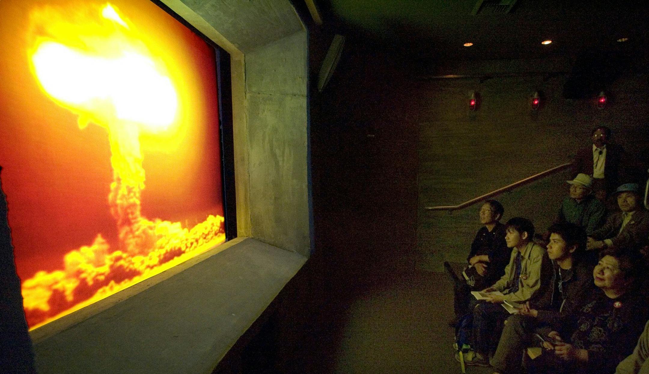 A group of Japanese visitors watches an atomic test in a sumulation theater at the Atomic Testing Museum in Las Vegas Wednesday, April 27, 2005.
