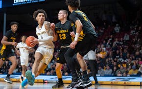 Totino-Grace’s Isaiah Johnson-Arigu drives on DeLaSalle’s Justin Johnson (23) and De'von Irvin (11) in the second half of the Eagles' 74-67 victor