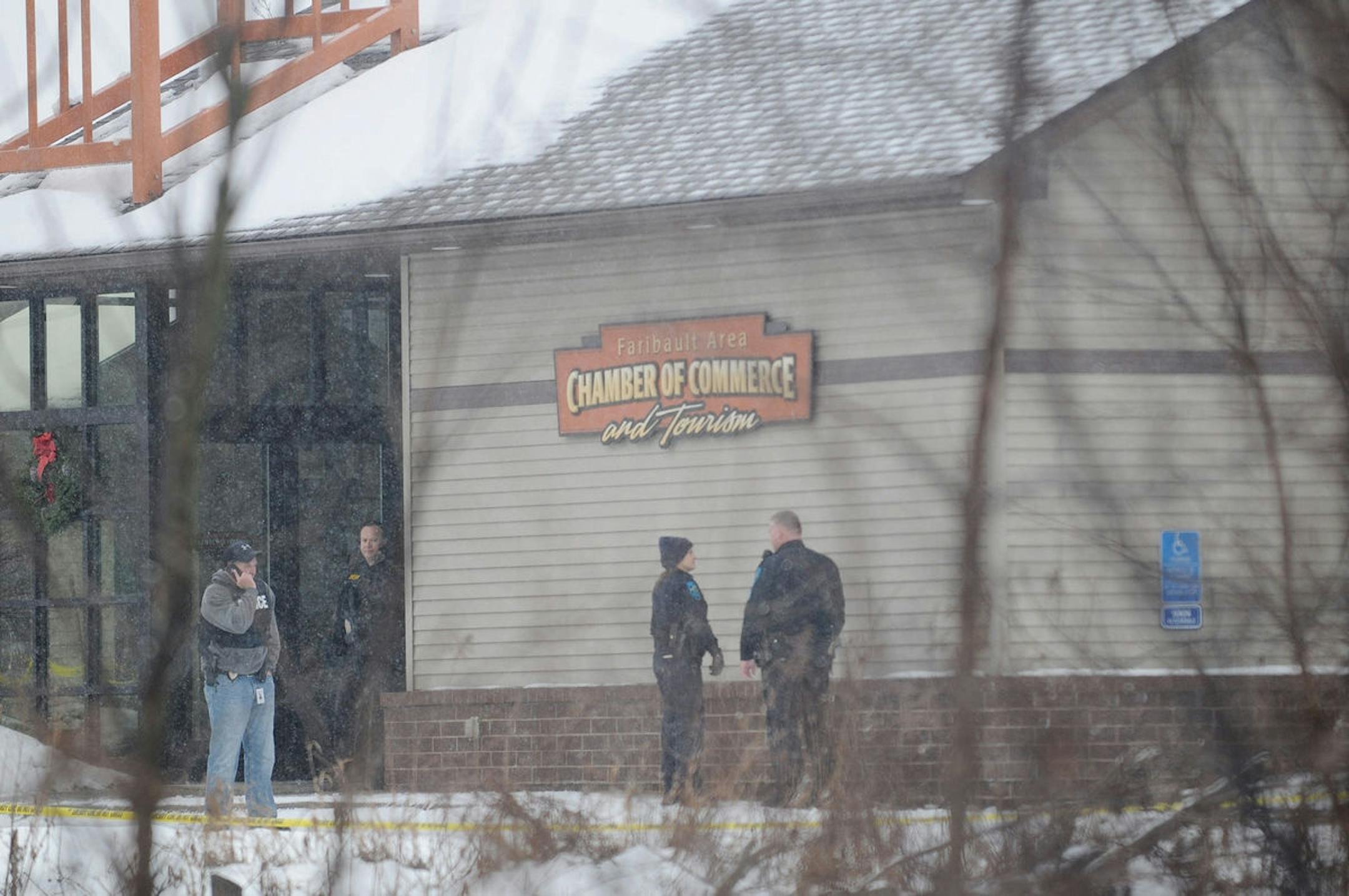 Officers gather outside the Faribault Area Chamber of Commerce on Friday, Dec. 23, after two people were found dead inside.