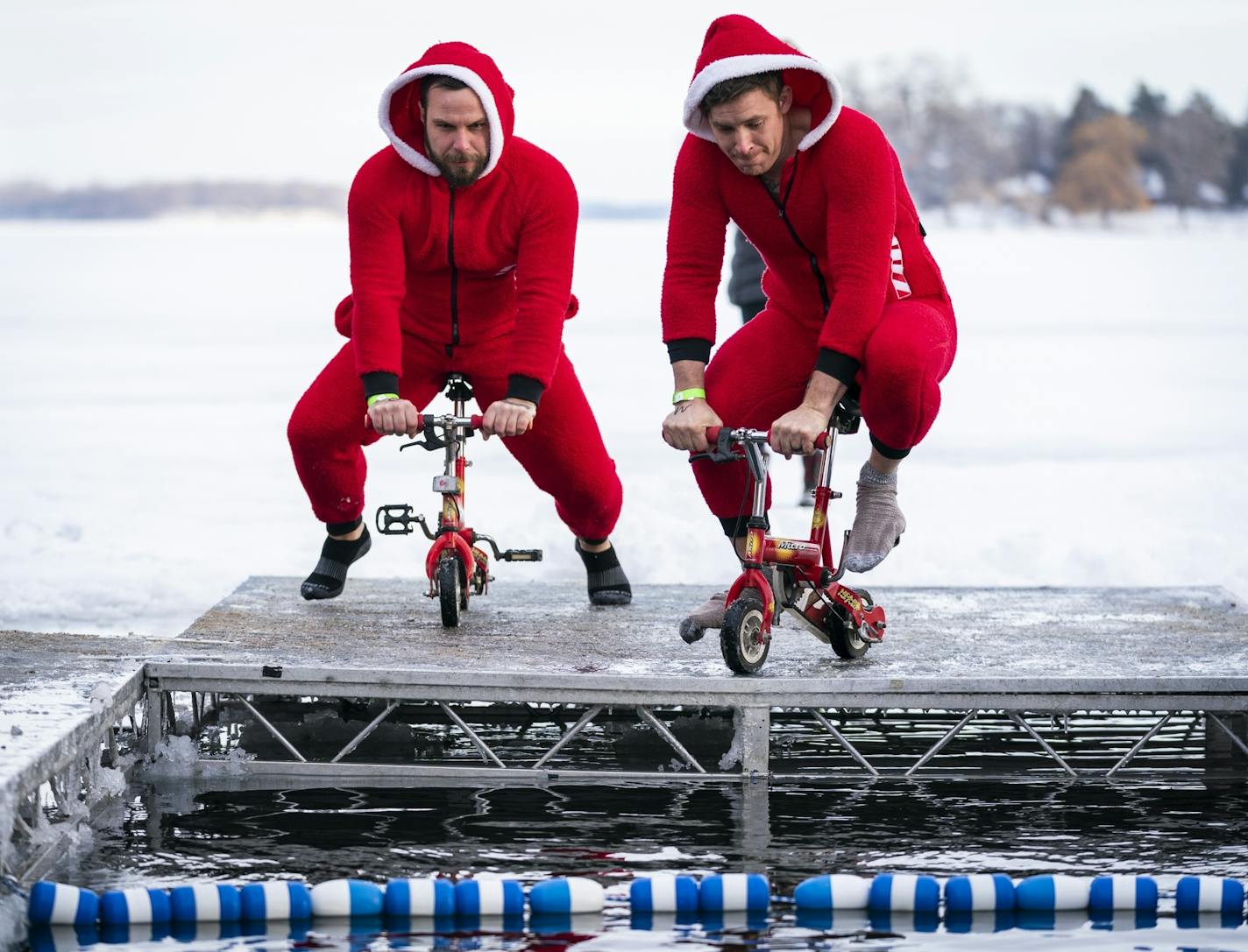 Matt Swayngim, left, of King of Prussia, Pa. and Nick Glomb of Seattle rode tiny bikes into the water during the ALARC Ice Dive.