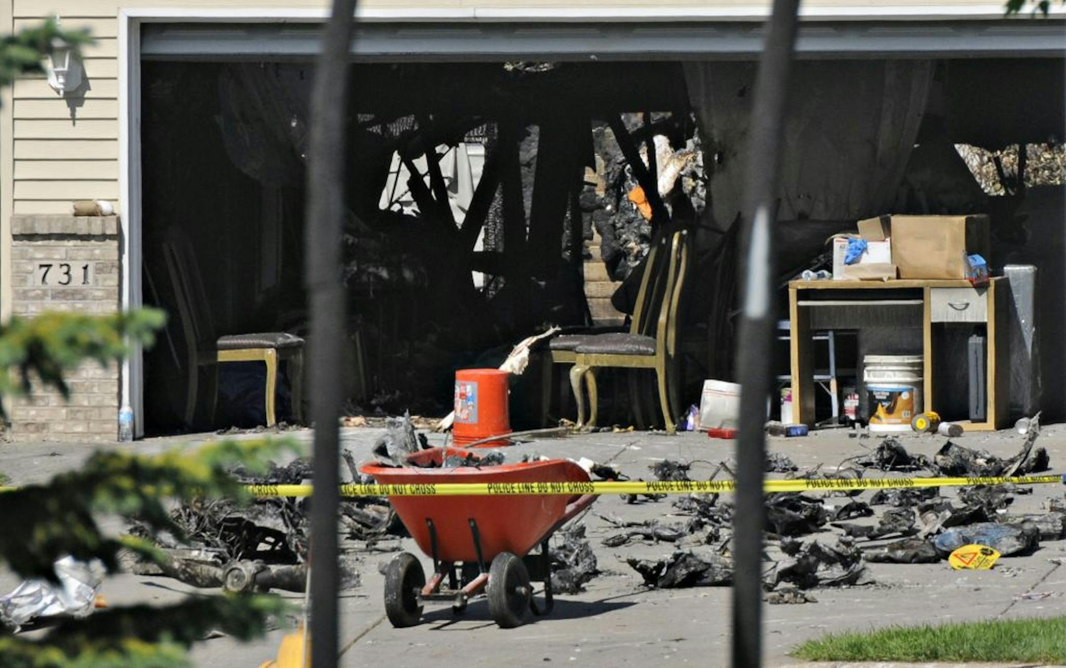 Pieces of the small plane that crashed are placed in the driveway while police waited for investigators from the The National Transportation Safety Board and the Federal Aviation Administration to arrive Saturday, June 2, 2014 in Sauk Rapids, Minn. The plane crash into the Sauk Rapids, Minn., home Friday night killed the pilot and passanger and destroyed the home.