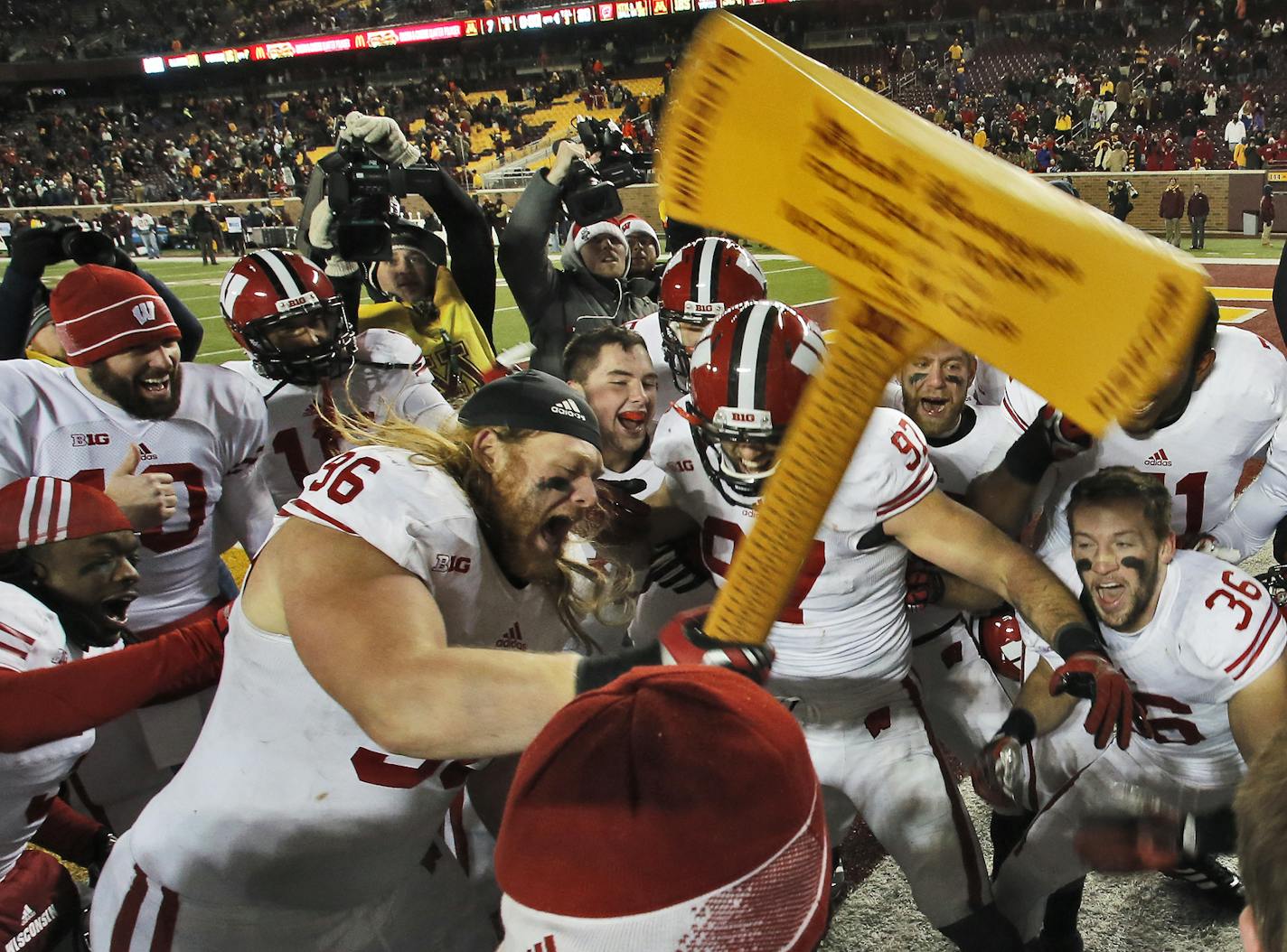 Wisconsin players "chopped" down a goal post with trophy Paul Bunyan Ax at the end of the game at TCF Bank Stadium in 2013.