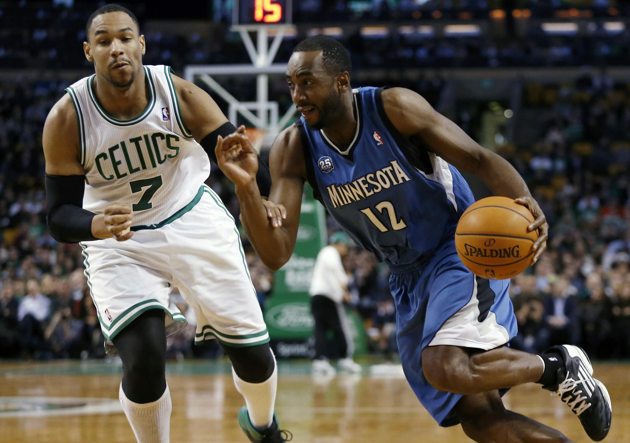 Minnesota Timberwolves' Luc Richard Mbah a Moute (12) drives past Boston Celtics' Jared Sullinger (7) in the second quarter of an NBA basketball game in Boston, Monday, Dec. 16, 2013.