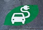 Electric car sign, charging station, green sign painted on street. Electric vehicle sign with car and plug, uploading place.