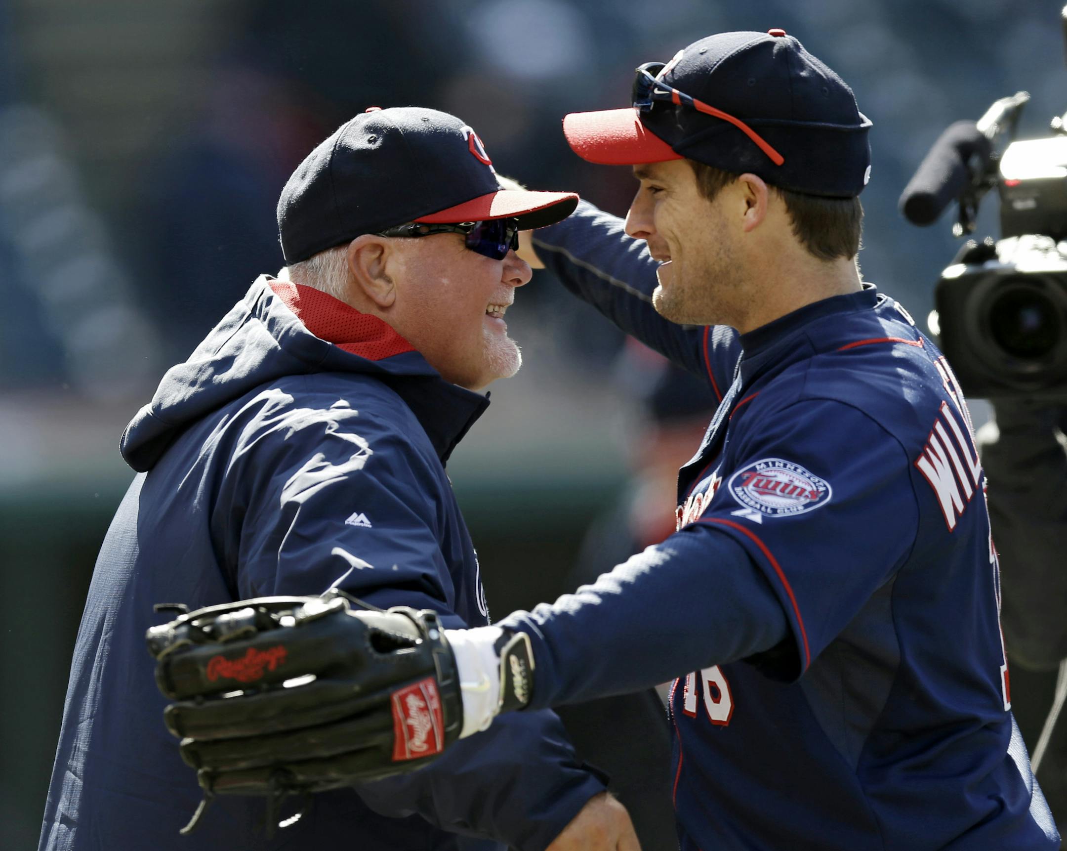 Minnesota Twins' Josh Willingham, right, congratulates Minnesota Twins manager Ron Gardenhire after the Twins defeated the Cleveland Indians 7-3 in a baseball game, Saturday, April 5, 2014, in Cleveland. The Twins win Saturday gave Gardenhire his 1,000th career victory. (AP Photo/Tony Dejak)