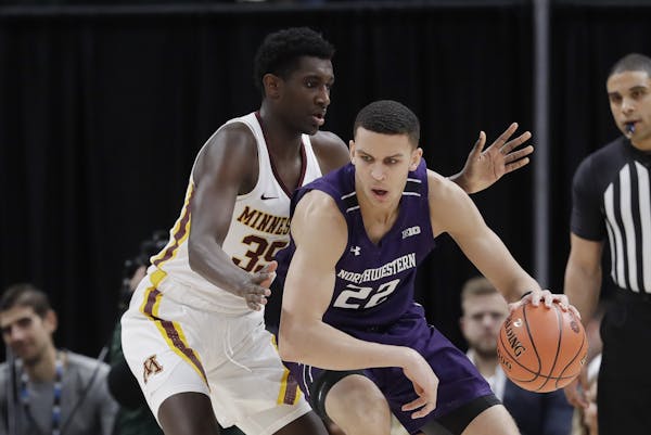 Northwestern's Pete Nance (22) works the ball against Minnesota's Isaiah Ihnen (35) during the first half of an NCAA college basketball game at the Bi