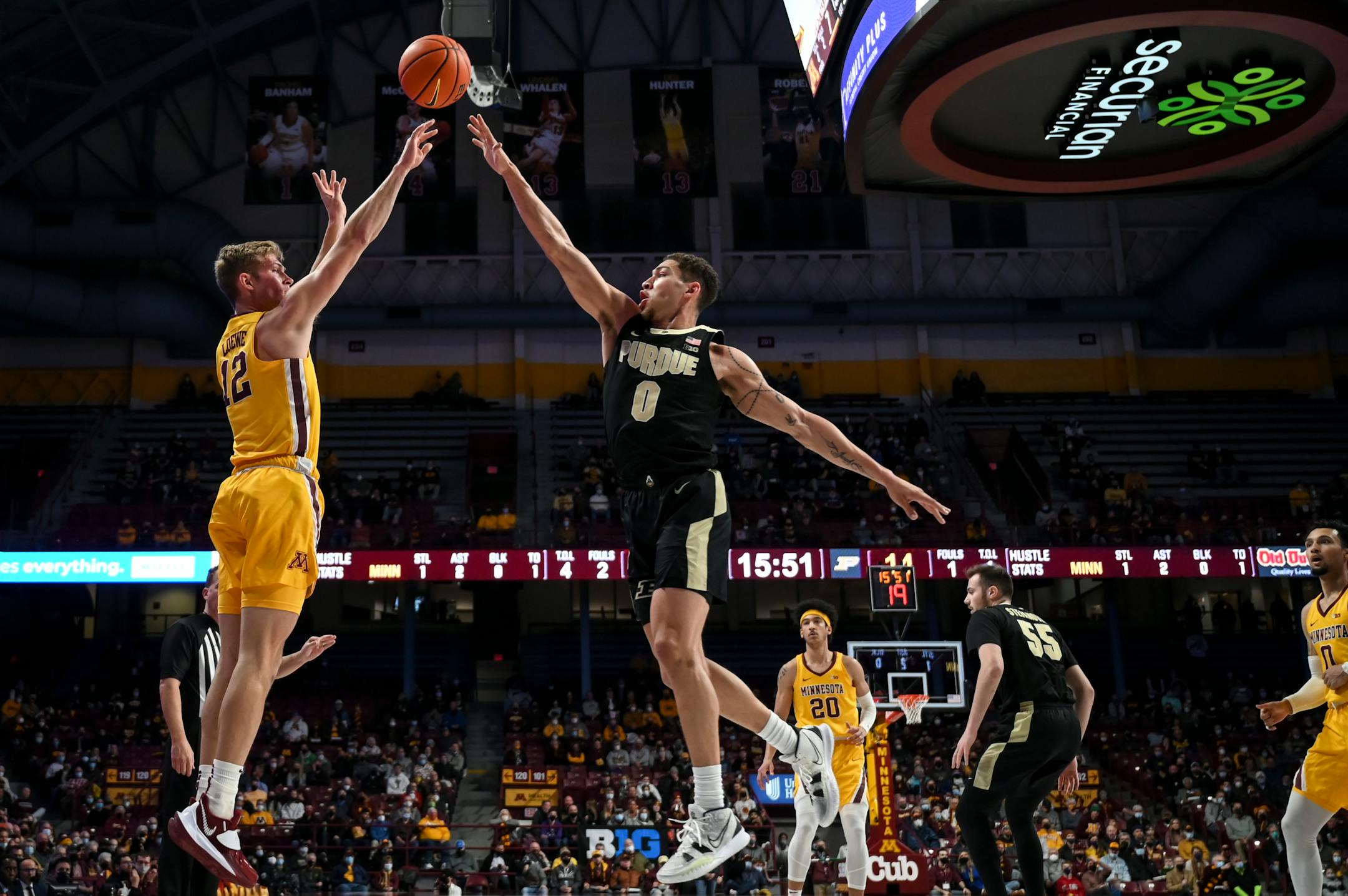 Minnesota Gophers guard Luke Loewe (12) shoots a 3-point basket as he was defended by Purdue Boilermakers forward Mason Gillis (0) in the first half during an NCAA men's basketball game between Minnesota and Purdue at Williams Arena in Minneapolis, Minn.