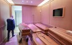 FILE - A funeral home in Piacenza, Italy, is full of coffins, March 25, 2020, due to the high number of deaths from the coronavirus. As the infection 