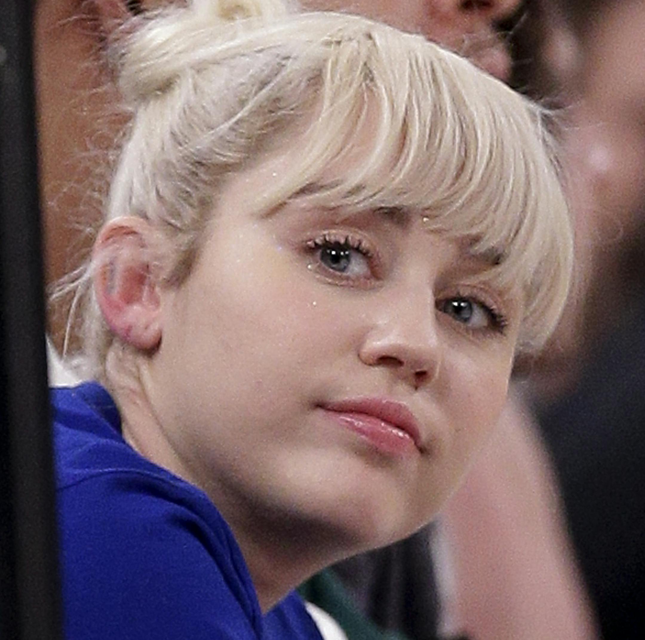 Miley Cyrus watches play between the New York Knicks and the Cleveland Cavaliers during the third quarter of an NBA basketball game, Saturday, March 26, 2016, in New York. (AP Photo/Julie Jacobson)