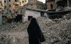 Fatima Mahmoud stands on what was once her home where she claims her husband was killed in an air strike.