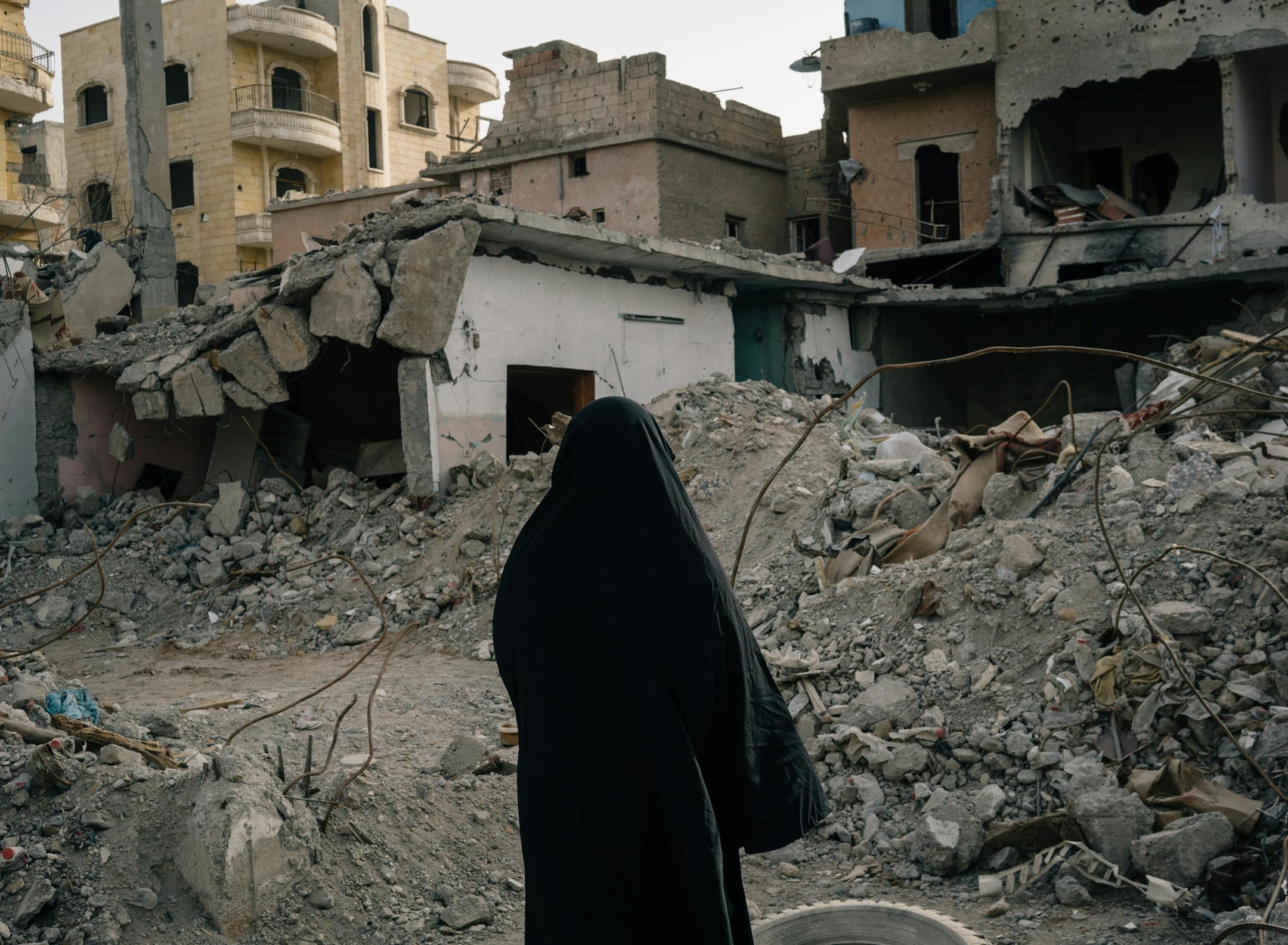 Fatima Mahmoud stands on what was once her home where she claims her husband was killed in an air strike.