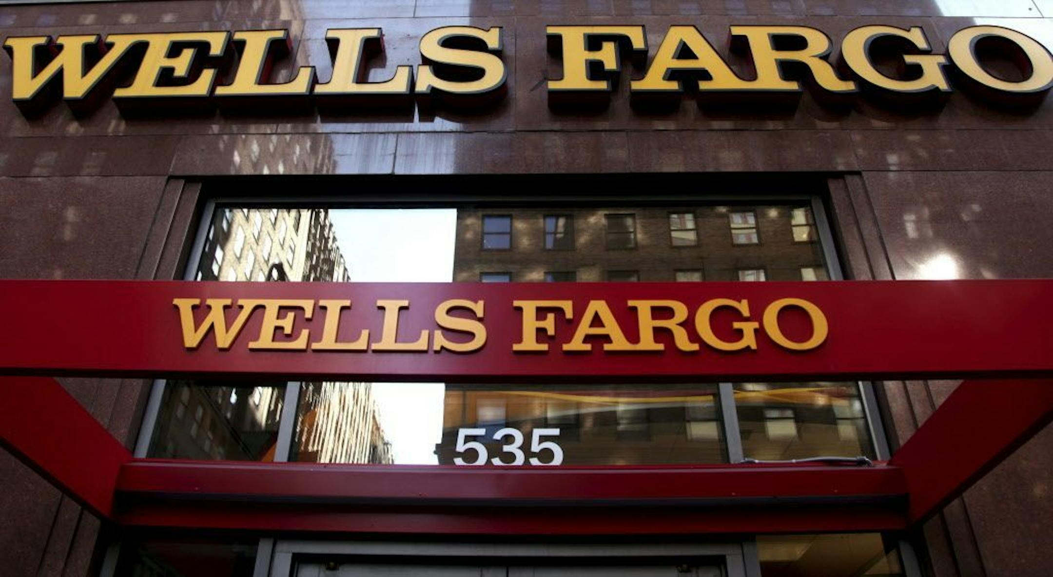 FILE - This May 6, 2012, file photo, shows a Wells Fargo sign at a branch in New York. Wells Fargo announced Tuesday, Jan. 10, 2017, it is completely restructuring how it pays tellers and other bank branch employees after a scandal over its aggressive sales practices.