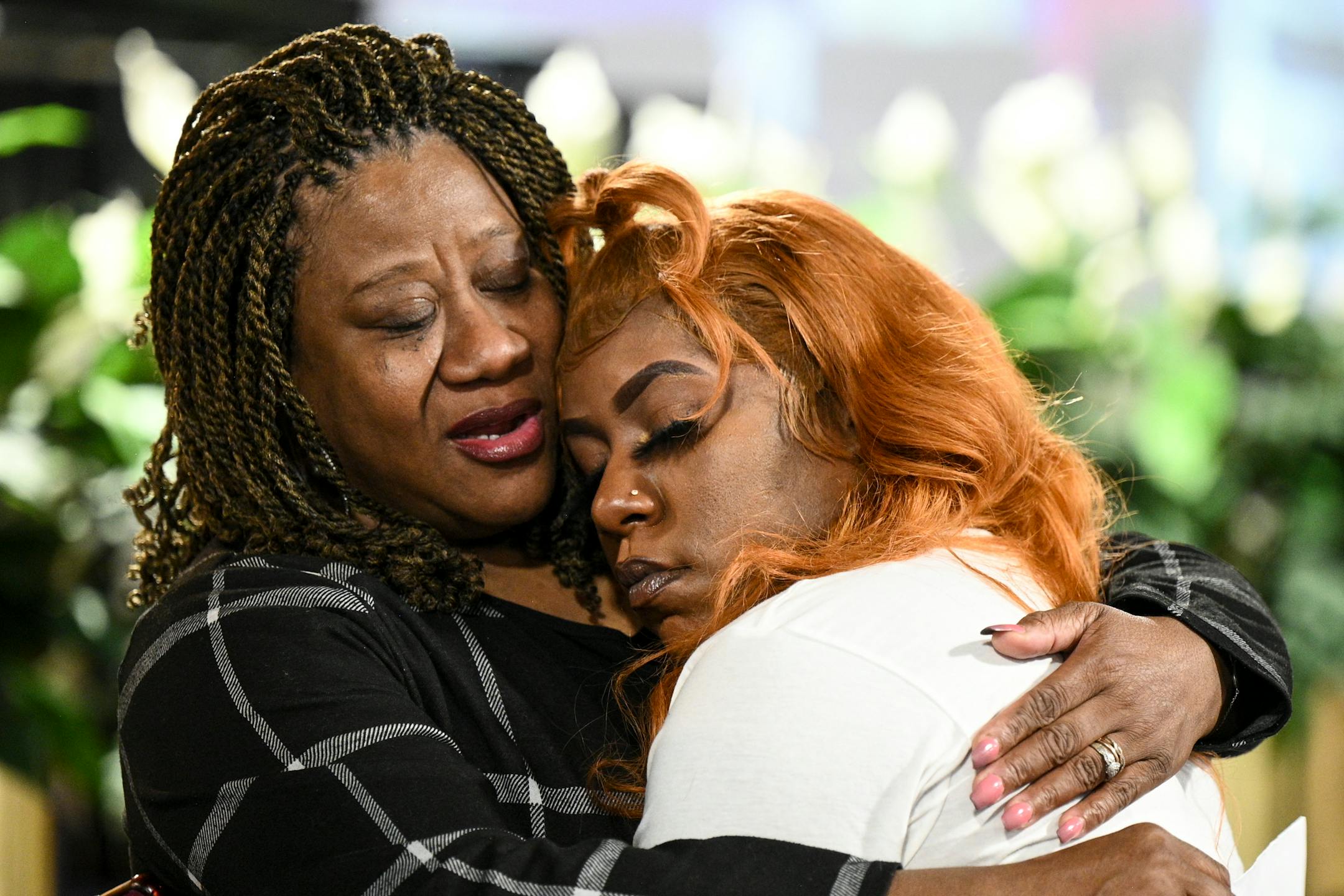 Maria Greer, mother of Zaria McKeever, embraces McKeever's first cousin Shardae Watkins Wednesday during a community meeting at Shiloh Temple.