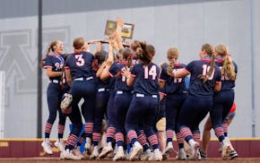 United South Central players heft the trophy after defeating Badger/Greenbush-Middle River 2-0 for the Class 1A softball state title at Jane Sage Cowl