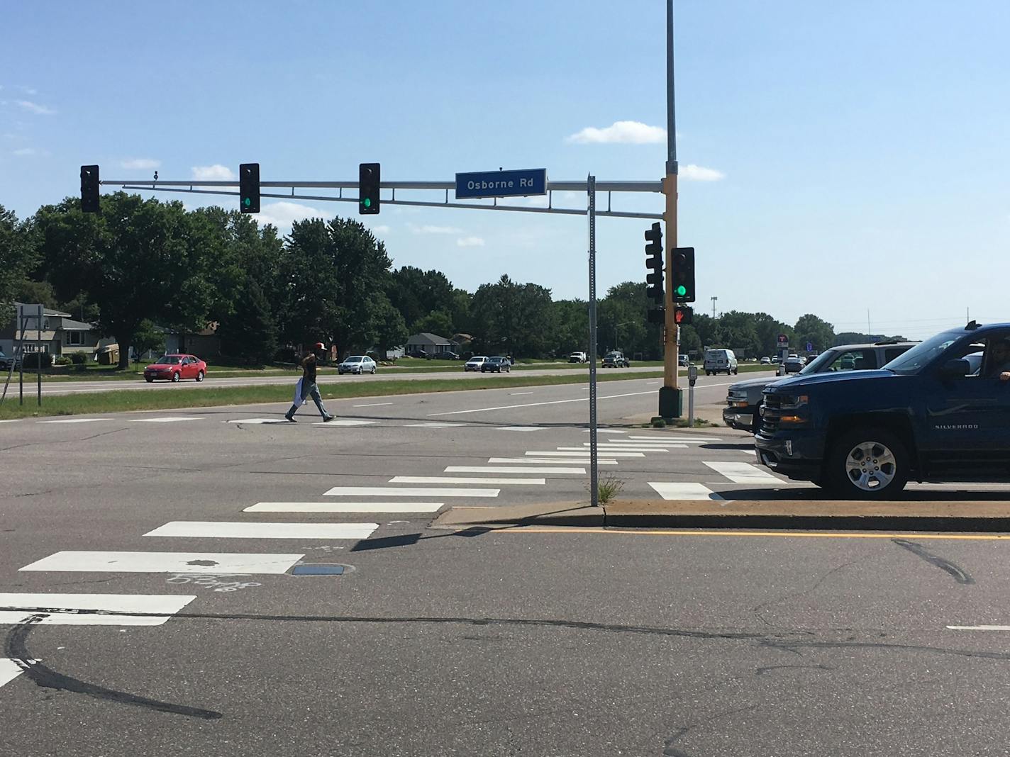 A pedestrian crosses at the intersection of University Avenue and Osborne Road, near where a man was struck by a vehicle and killed in March.