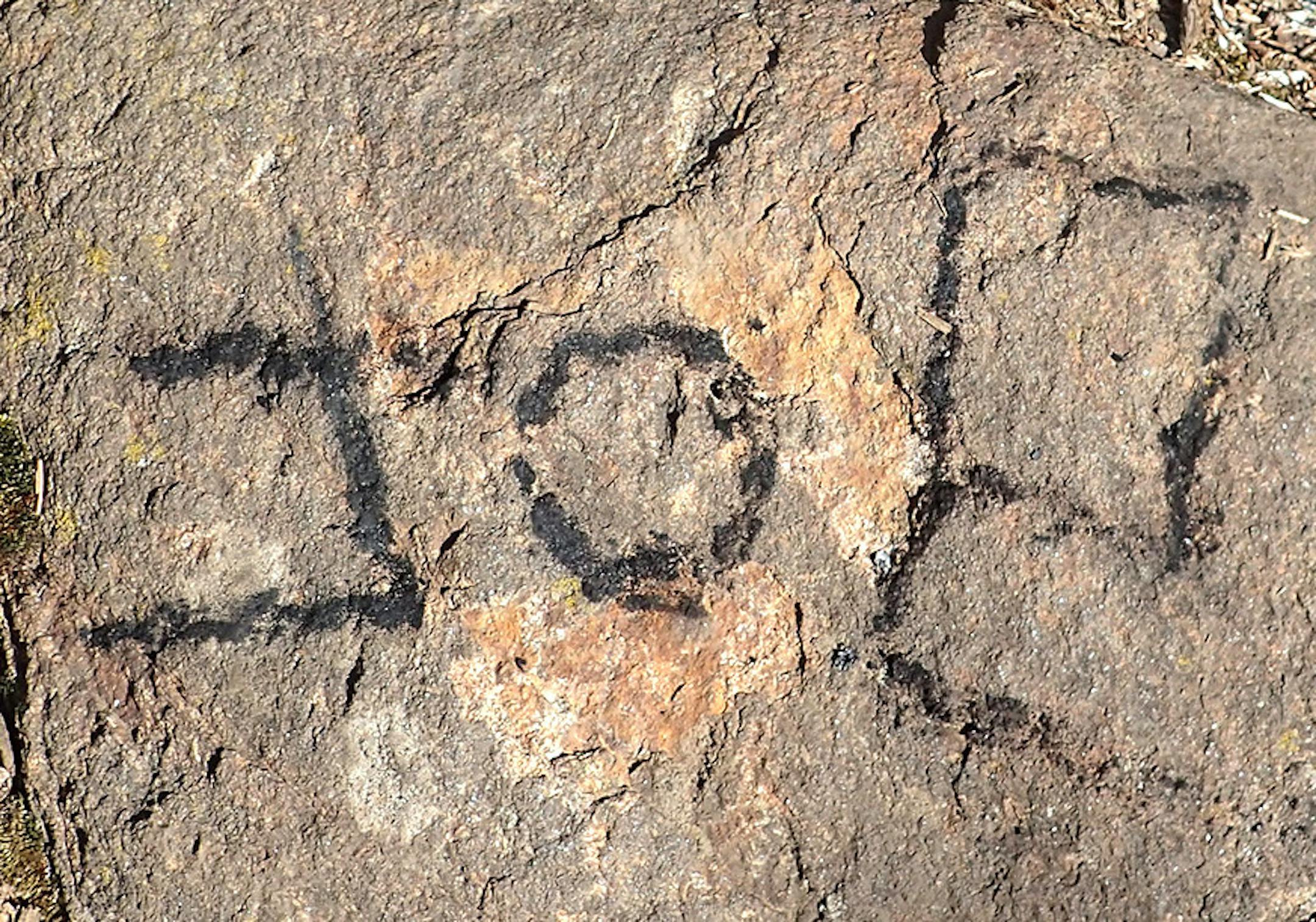 Using the charred tip of a fire-tending stick, Joe Kennedy passed a little bit of down time playing tic-tac-toe on the rocks of his family's campsite, then writing his name.