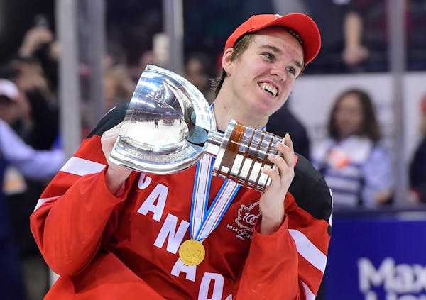 Canada's Connor McDavid skates with the trophy following his team's 5-4 win over Russia in the title game at the hockey World Junior Championship in T