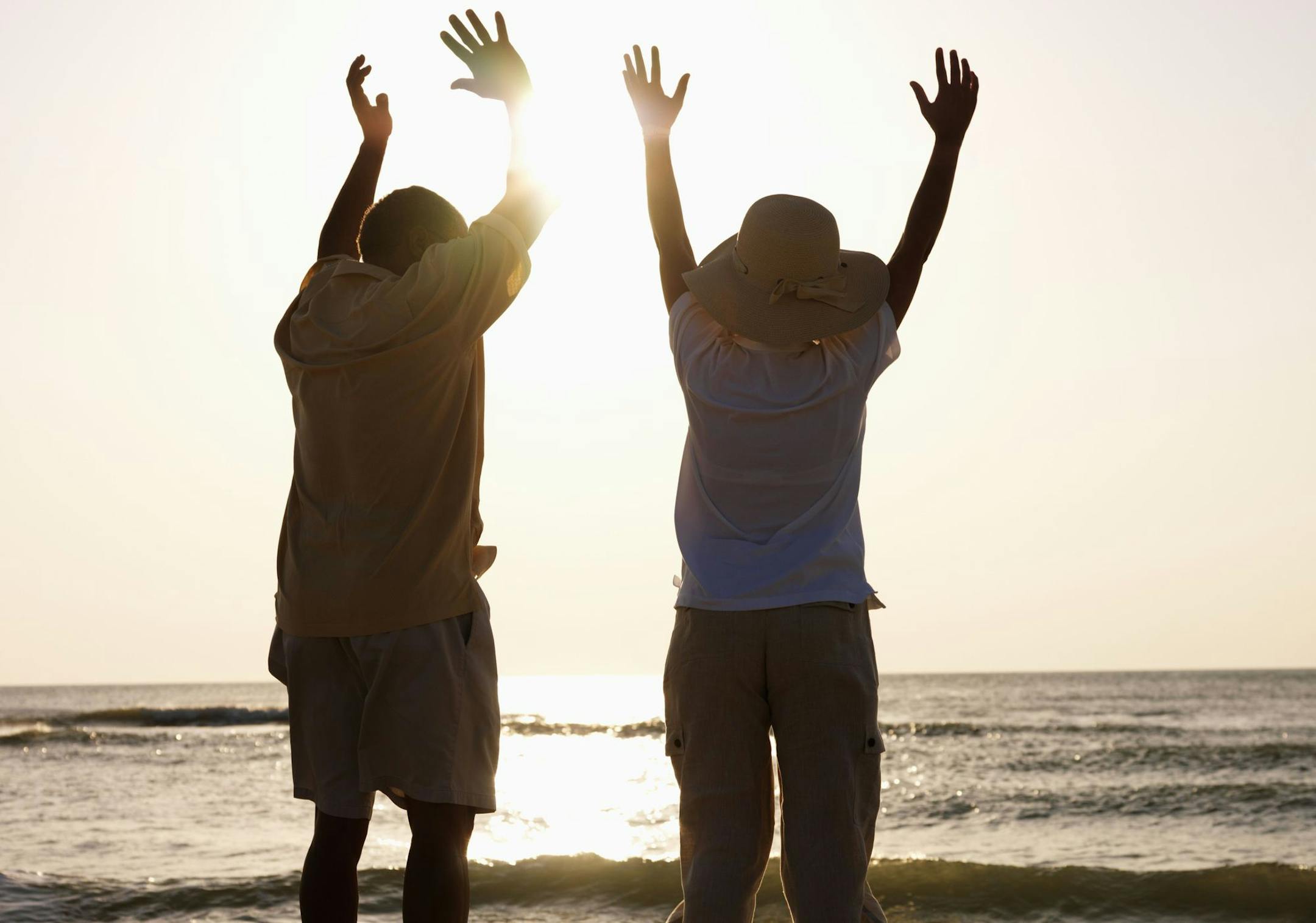 Couple Jumping on Beach at Sunset