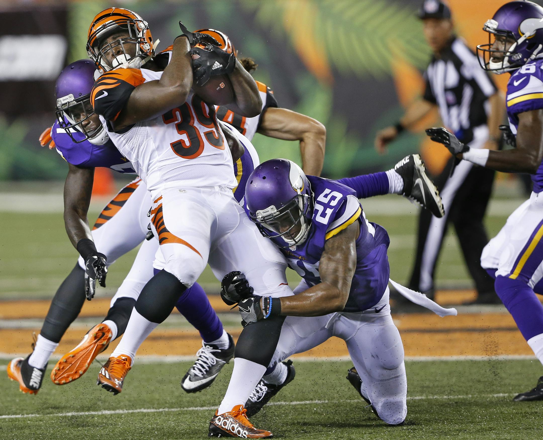 Cincinnati Bengals running back Tra Carson (39) is tackled by Minnesota Vikings cornerback Jabari Price (25) and safety Jayron Kearse, left, during the second half of an NFL preseason football game, Friday, Aug. 12, 2016, in Cincinnati. (AP Photo/Frank Victores) ORG XMIT: MIN2016081415223028