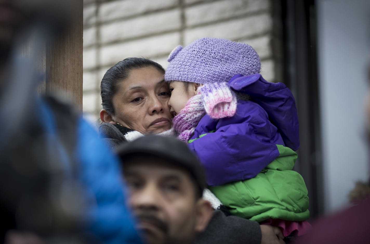 Marta Pacheco held her daughter Heidi as she joined about a dozen people protesting rising rents at buildings in south Minneapolis.