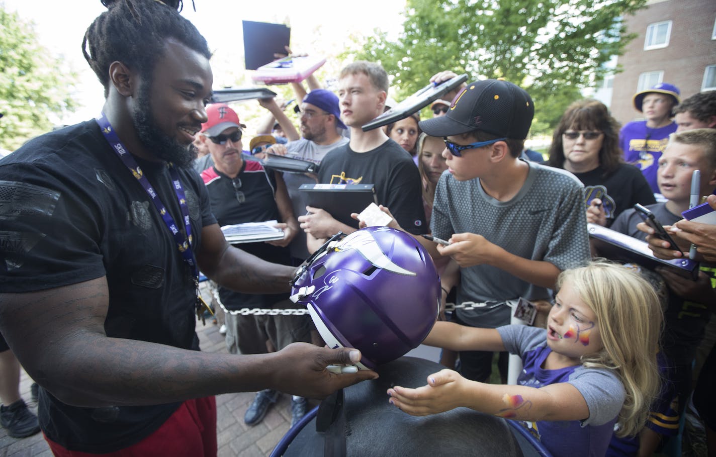 Vikings rookie running back Dalvin Cook autographed a helmet for Tatum Smith, 6, as rookies and select players arrived at training camp in Mankato on Sunday.