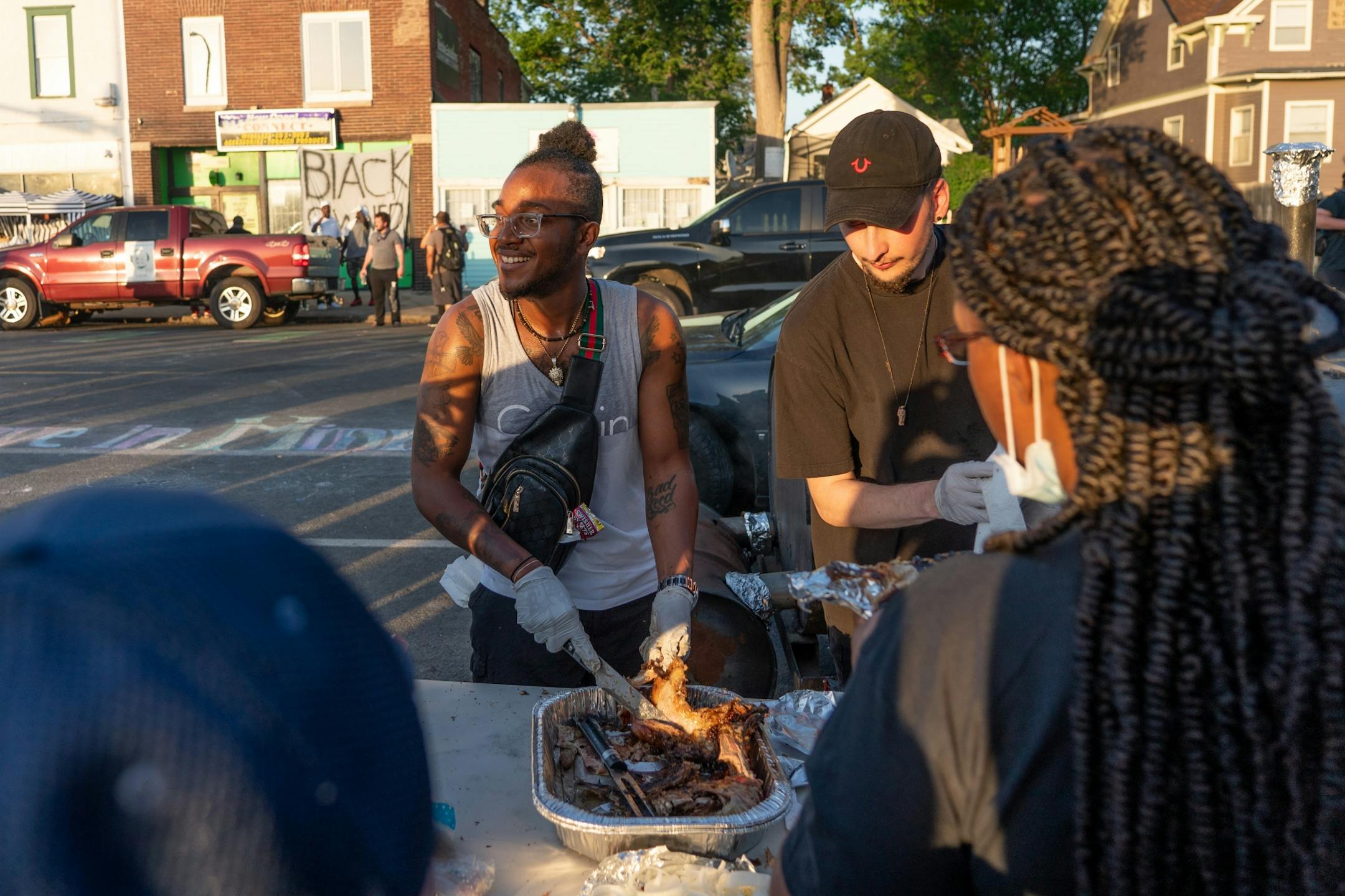 Volunteers (names not given) work the BBQ station at the George Floyd memorial at 38th Street and Chicago Avenue.