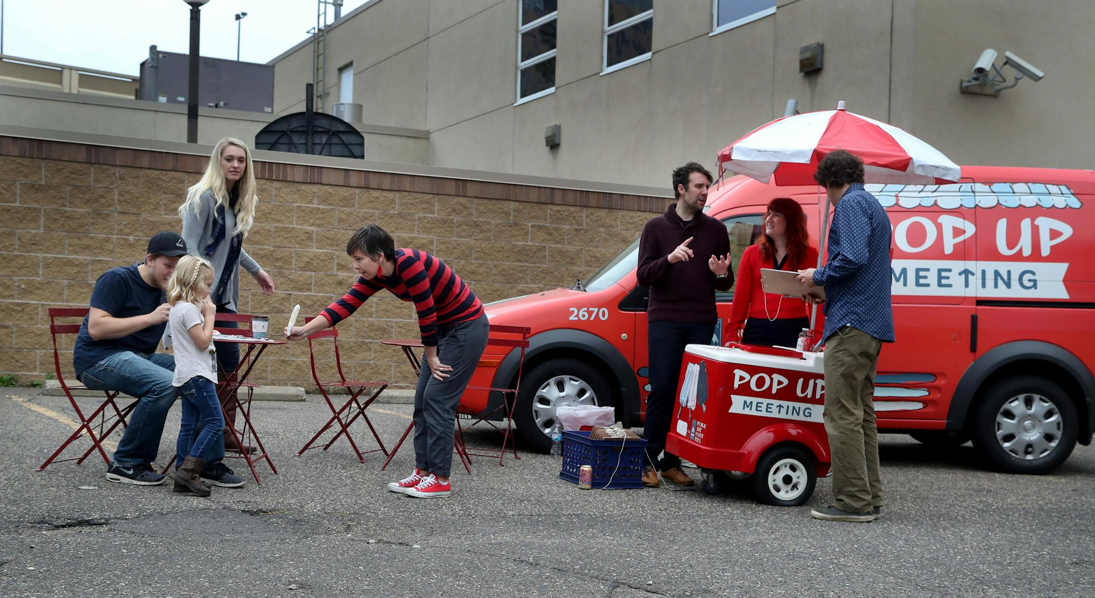 Pop Up Meeting truck, the two-year-old program and the brainchild of City Artist Amanda Lovelee, will be at its last event -- the year-end party for Urban Flower Field at Pedro Park Saturday, Sept. 24, 2016, in St. Paul, MN. Pop Up Meeting takes the public meeting to the public, and gives away popsicles as a reward for participating.Here, Lovelee, fourth from left, is seen handing out a popsicle to Allesandro Grover, 4, whose parents Makenzie Grover, back rear left, and Dylan Cherveny, seated le