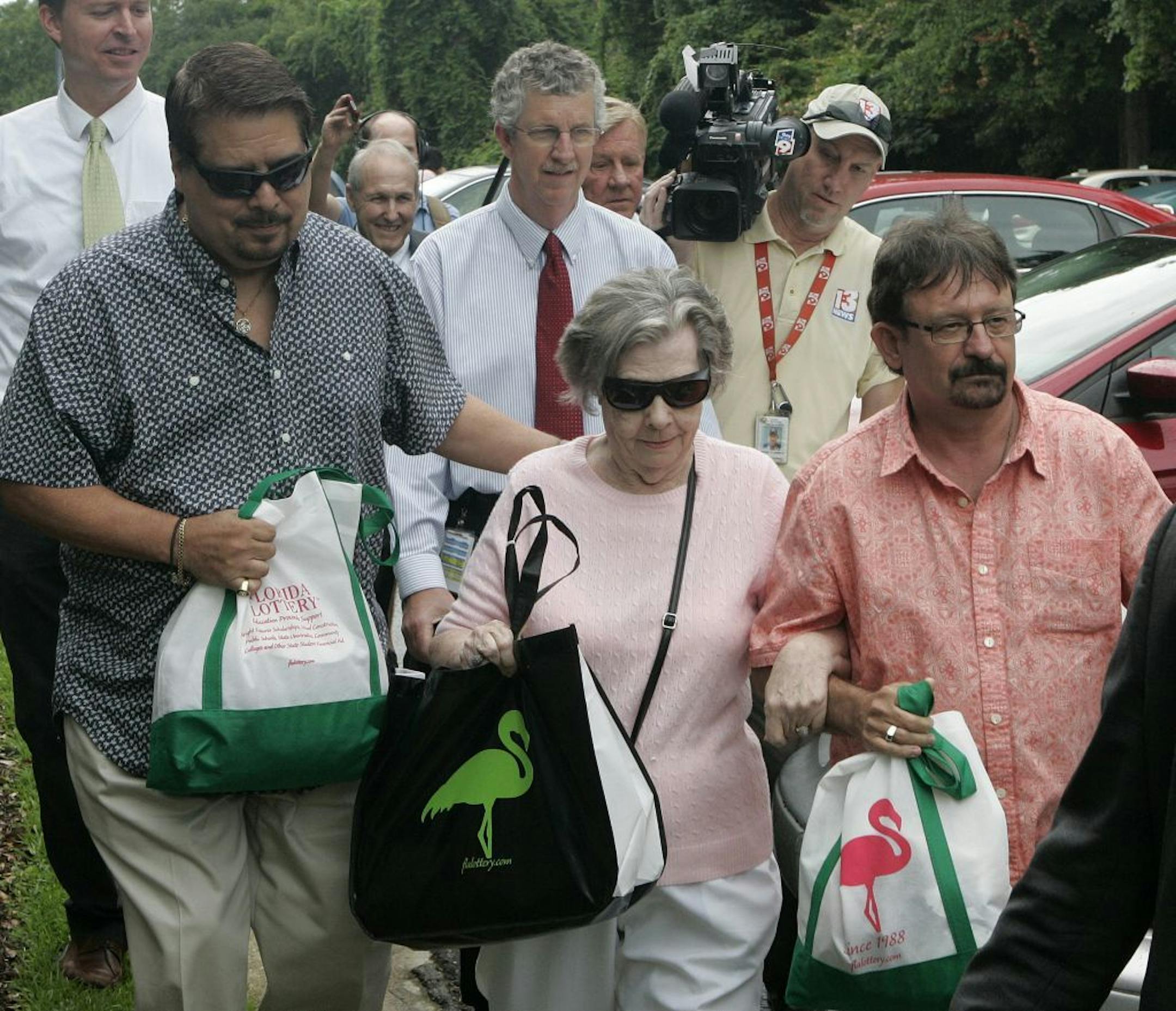 Powerball winner Gloria C. Mackenzie, 84, leaves the lottery office escorted by her son Scott Mackenzie, right, after claiming a single lump-sum payment of about $370.9 million before taxes on Wednesday, June 5, 2013, in Tallahassee, Fla. Officials say she is the largest sole lottery winner in U.S. history. She did not speak to reporters outside lottery headquarters, leaving in a silver Ford Focus with family members.