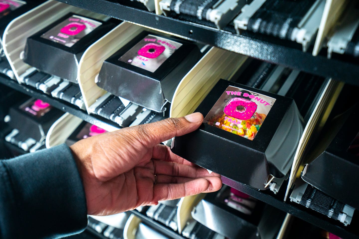 Bradley Taylor, a founder of The Donut Trap, restocks his donut vending machine at his first ever location in Can Can Wonderland.