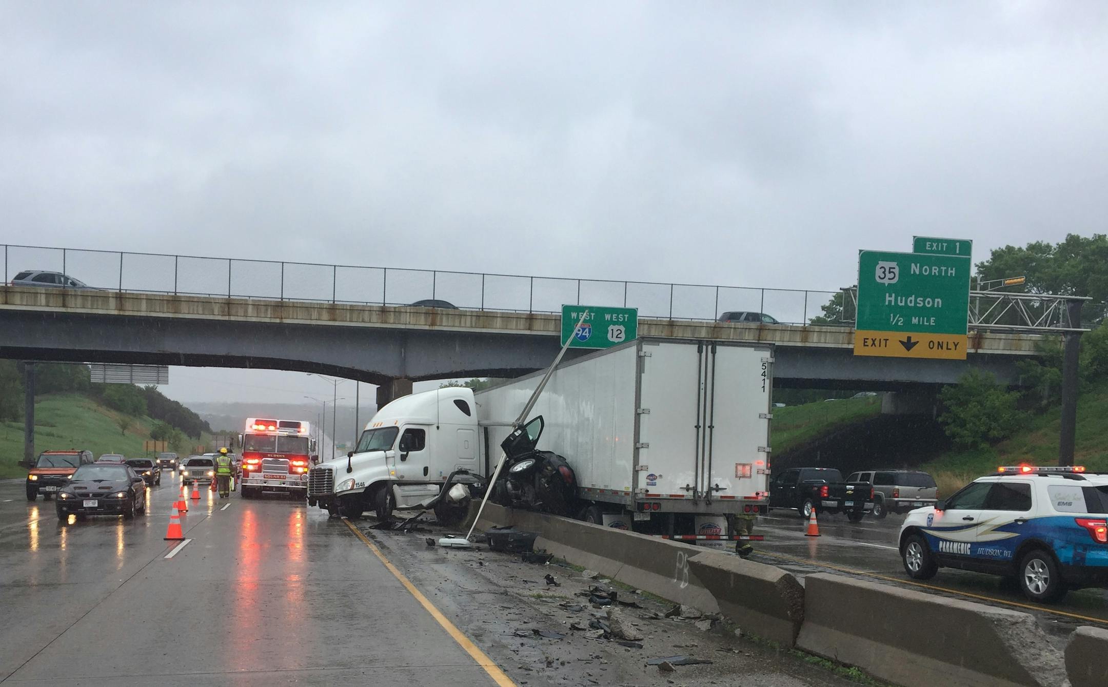 A car is pinned between a semi and the median after a collision on Interstate 94 westbound near Hudson, Wis., on Saturday, May 20, 2017.