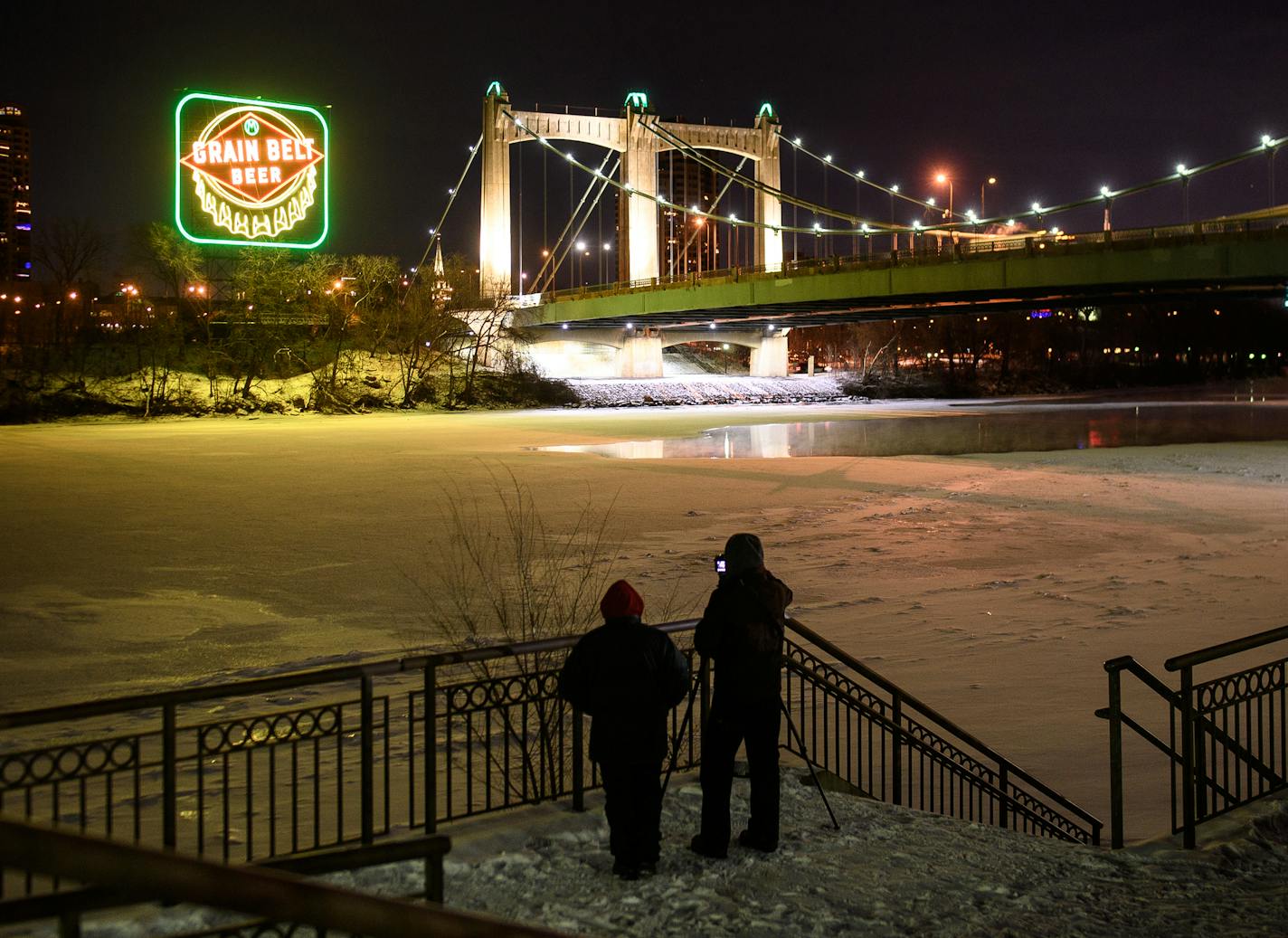 Photographers took photos across the Mississippi from the Grain Belt sign Saturday night after a relighting ceremony. ] AARON LAVINSKY &#xef; aaron.lavinsky@startribune.com A ceremony was held for the relighting of the Grain Belt sign in Minneapolis Saturday, Dec. 30, 2017. Revelers lined up along the Hennepin Bridge and along the Mississippi River.