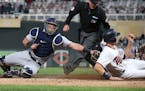 Minnesota Twins' Max Kepler, right, is tagged out by Detroit Tigers catcher James McCann as he tried to score on a single by Eduardo Escobar in the fi