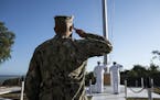 Members of the military salutde the U.S. flag in Guantánamo Bay, Cuba, in April. Set up nearly 18 years ago to house detainees in the war on terroris