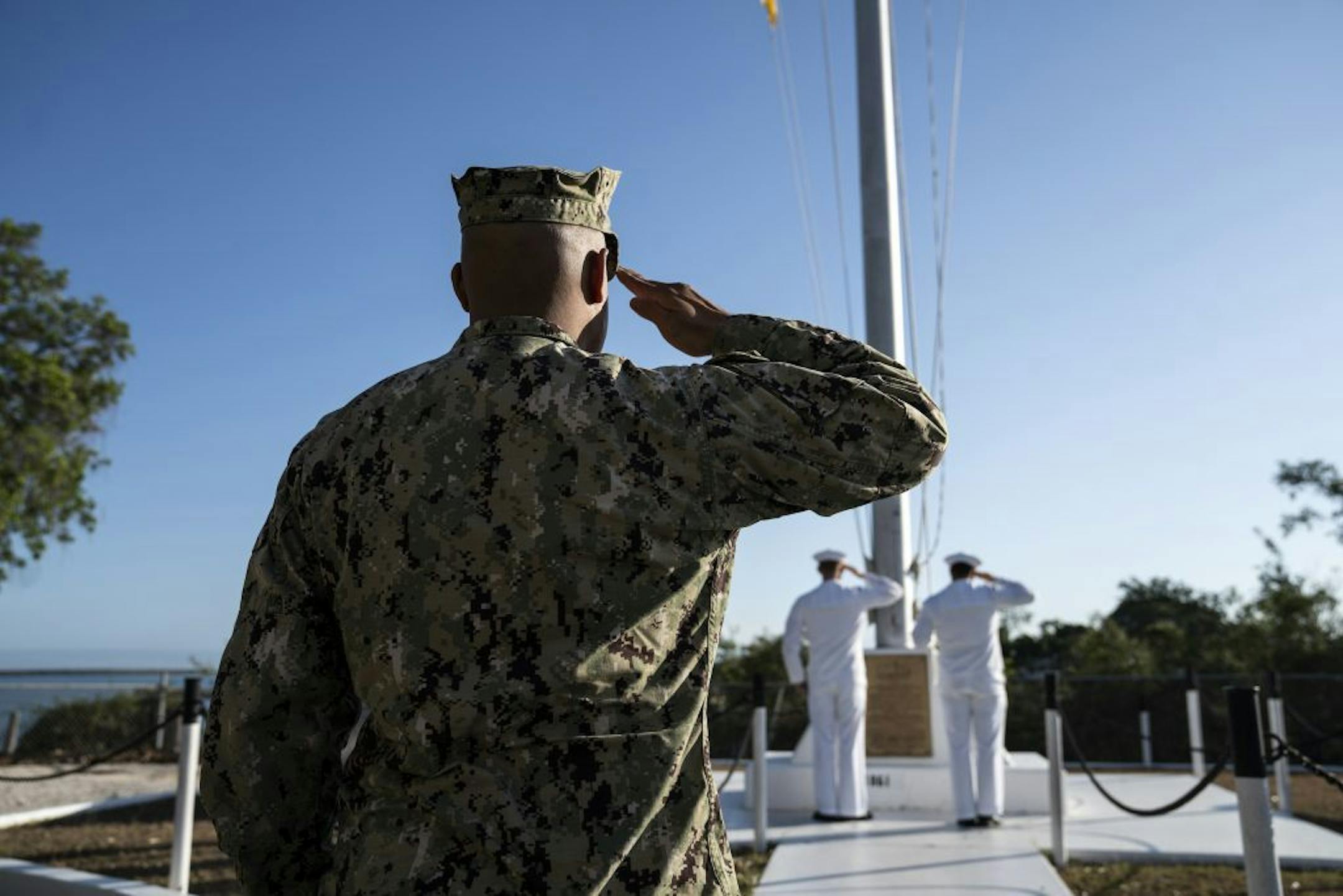 Members of the military salutde the U.S. flag in Guantánamo Bay, Cuba, in April. Set up nearly 18 years ago to house detainees in the war on terrorism, the prison on the remote naval base has grown into what appears to be the most expensive on Earth.