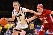 Indiana’s Sara Scalia, right, worked to defend Iowa’s Molly Davis in the Hoosiers’ 84-57 loss on Saturday in Iowa City.