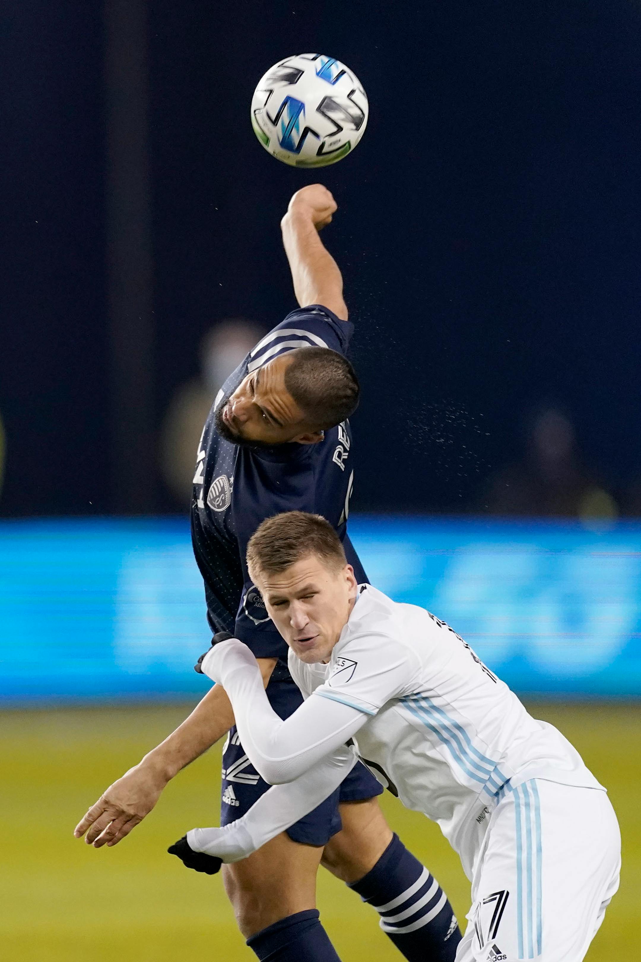 Sporting Kansas City defender Winston Reid, back, and Minnesota United midfielder Robin Lod (17) vie for the ball during the first half of an MLS soccer match Thursday, Dec. 3, 2020, Kansas City, Kan. (AP Photo/Charlie Riedel)