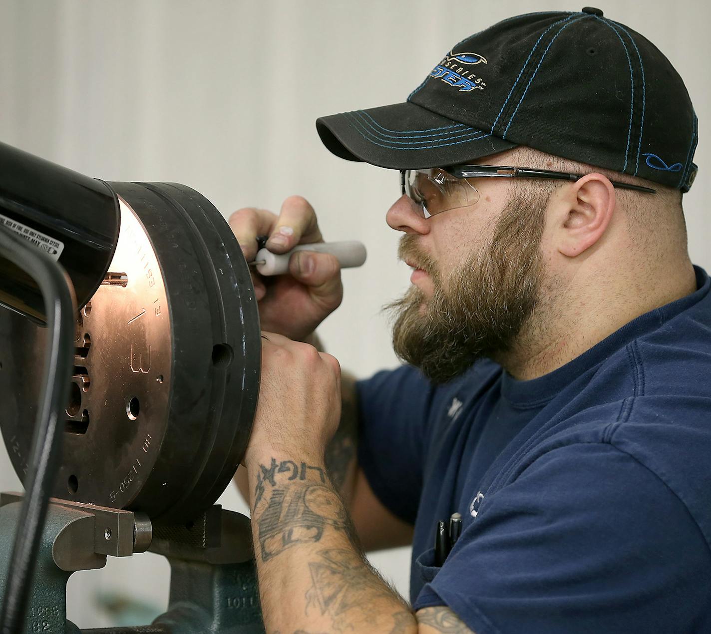 Matt Wille was re-hired at Alexandria Industries six months ago as a die corrector after a five year absence and after studying machining at Alexandria Technical College. Here he is cleaning up and polishing a die used to extrude molten aluminum. "I like being back with a faith based company. I like the way they treat people," he said.