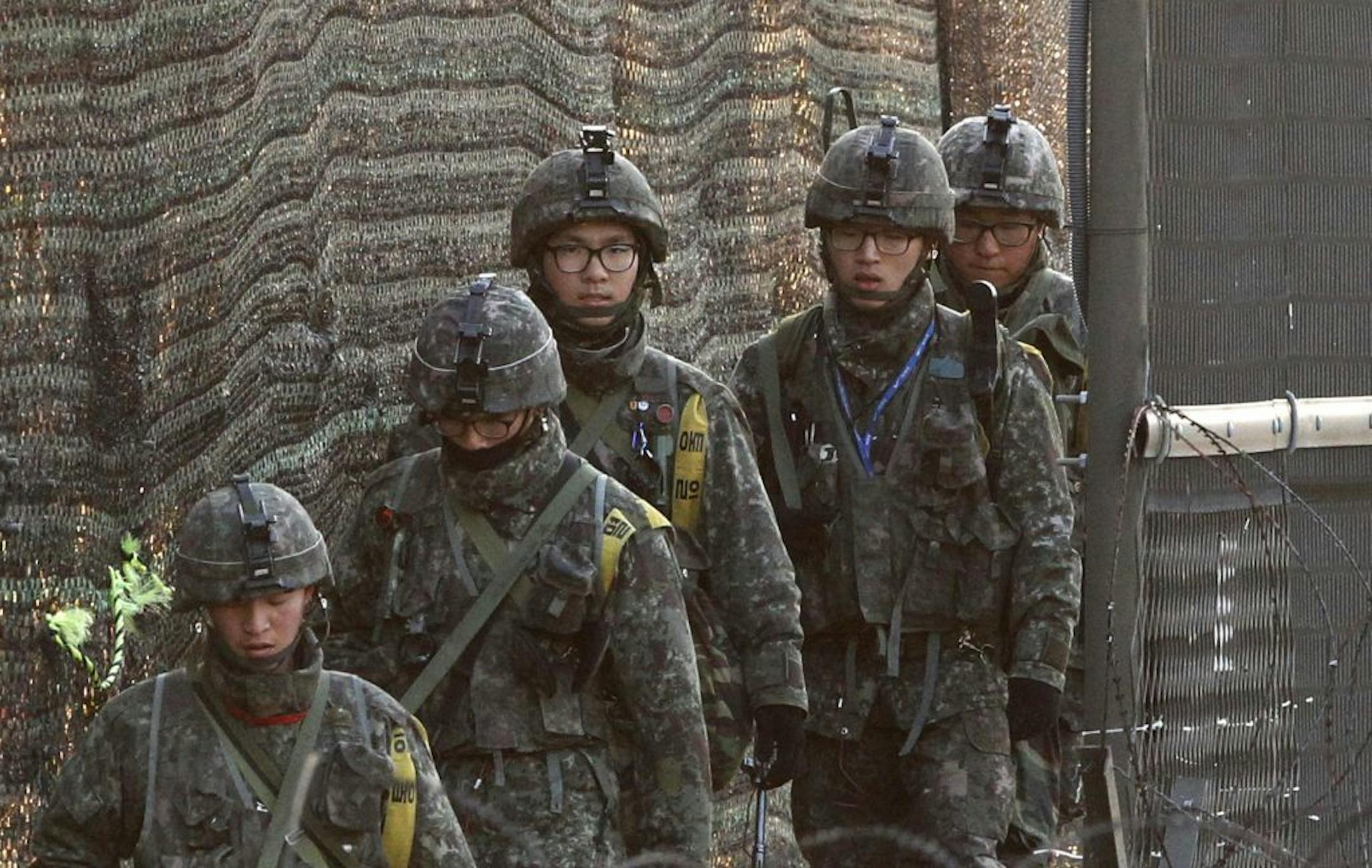 South Korean army soldiers patrol along a barbed-wire fence near the border village of Panmunjom in Paju, South Korea, Wednesday, March 27, 2013. North Korea said Wednesday that it had cut off a key military hotline with South Korea that allows cross border travel to a jointly run industrial complex in the North, a move that ratchets up already high tension and possibly jeopardizes the last major symbol of inter-Korean cooperation.