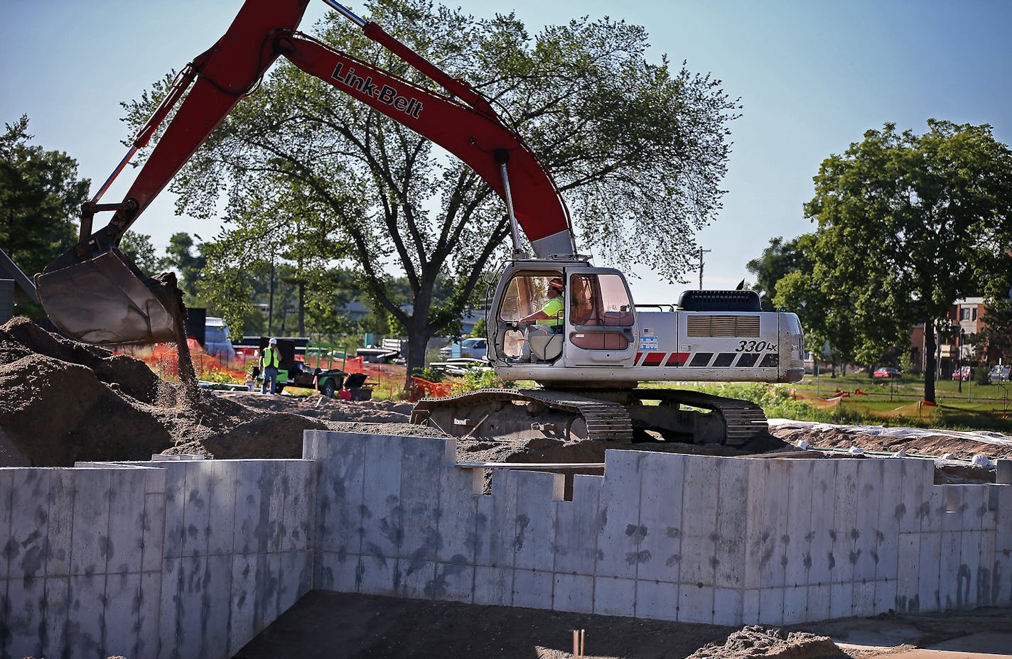 Construction crew worked on a filtration system and swimming pool early Wednesday, July 16, 2014 in Minneapolis, MN. It is a first-of-its-kind-in-the-nation swimming pool that is being built in north Minneapolis. It will have a natural filtration system, using nearby plants to treat the water instead of chemicals. It was to open in August but has been delayed until 2015. ] (ELIZABETH FLORES/STAR TRIBUNE) ELIZABETH FLORES &#x2022; eflores@startribune.com