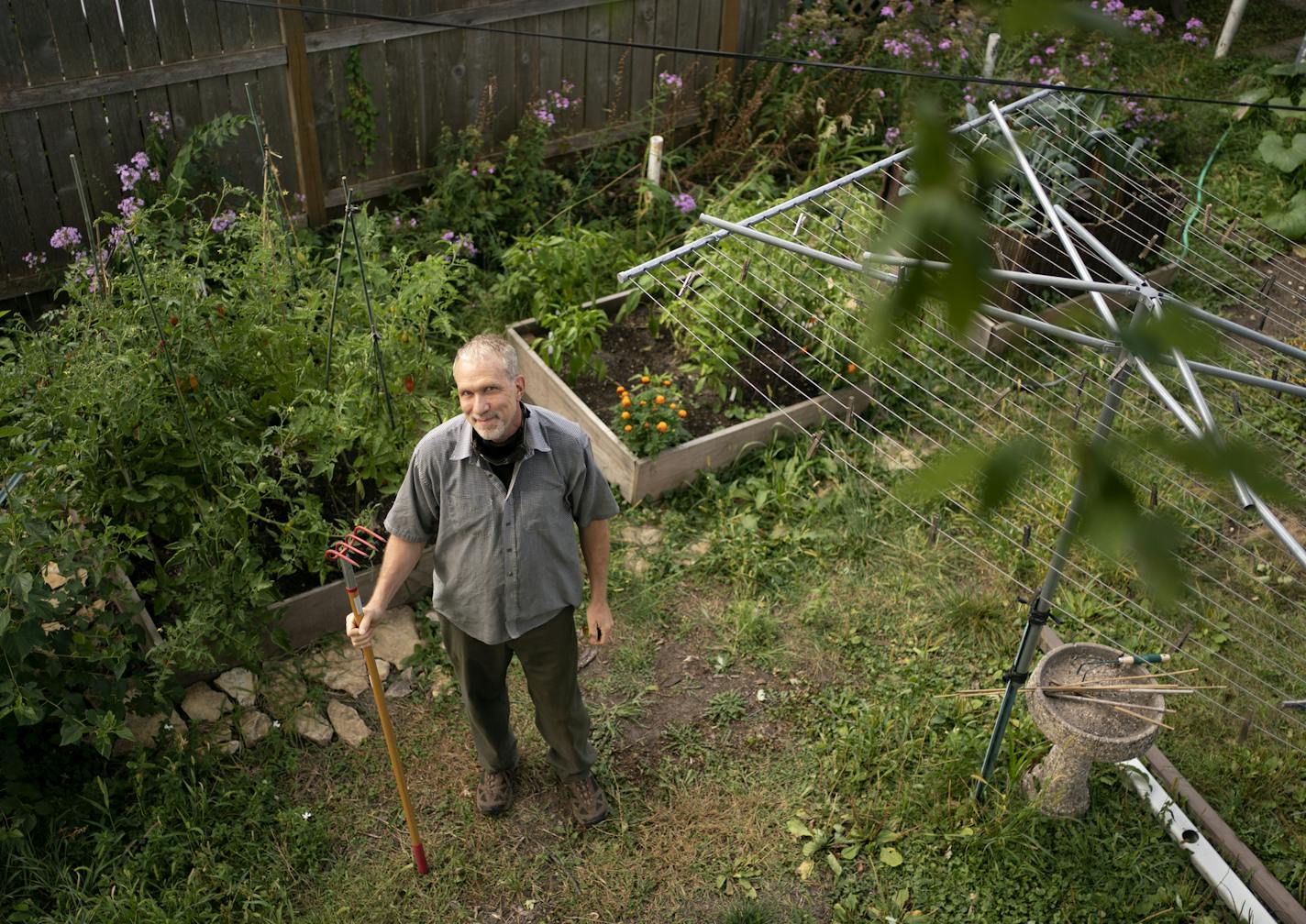 Christopher Lutter-Gardella tended to his raised-bed gardens, which flow from the side of his Minneapolis house into his backyard.