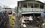 Norma Rios stands in front of her destroyed house in the aftermath of Hurricane Maria, in Catano, Puerto Rico, Wednesday, Sept. 27, 2017. Many are wai